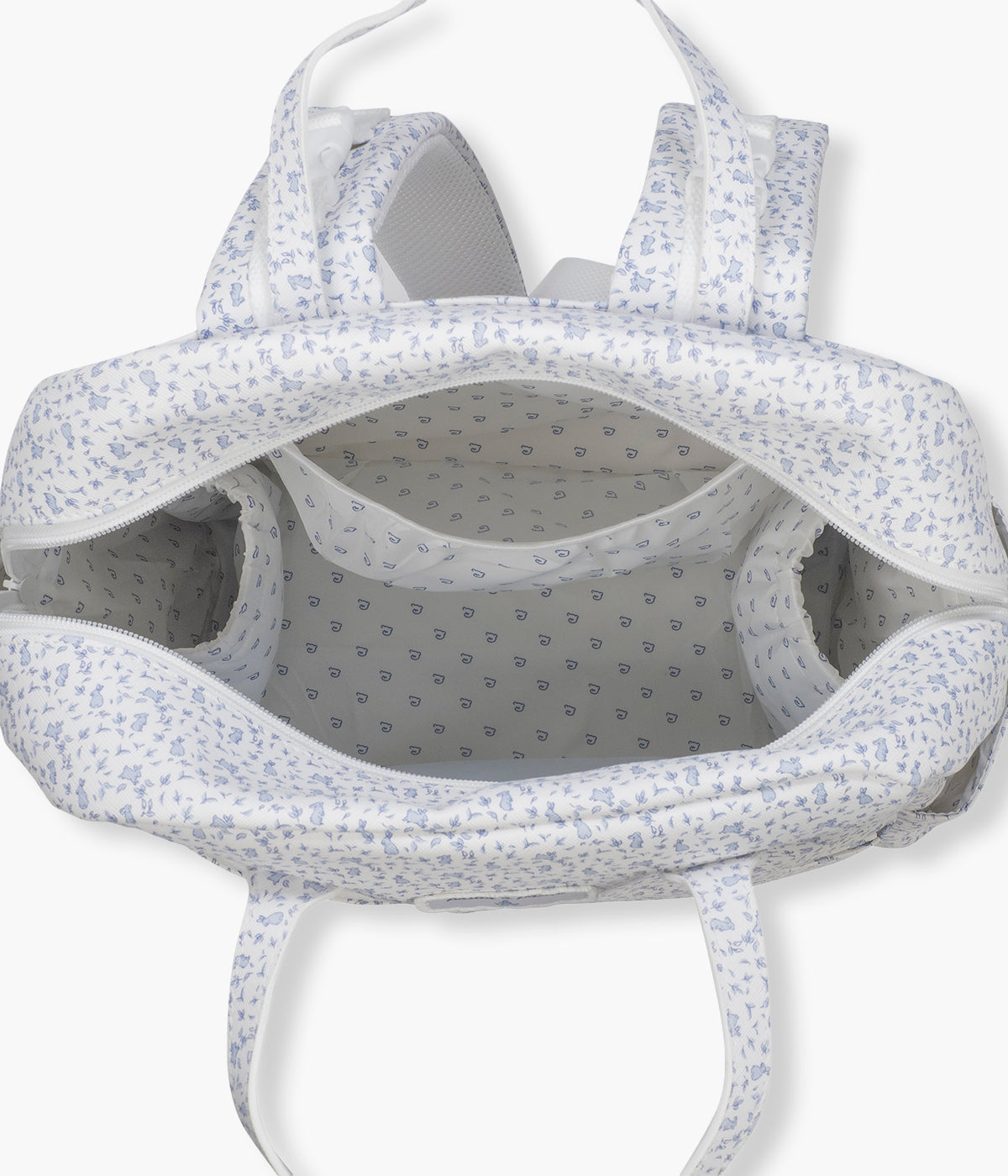 Vista do interior da mochila de maternidade Maison Tender Rabbits da Pasito a Pasito. Fabricada em pele vegana com tratamento resistente à água, esta mochila de padrão coelhos azul em fundo branco oferece um interior espaçoso e bem organizado, com bolso térmico para biberão, bolso plastificado para roupa húmida e vários compartimentos para manter todos os essenciais facilmente acessíveis. Inclui ainda um resguardo portátil.
