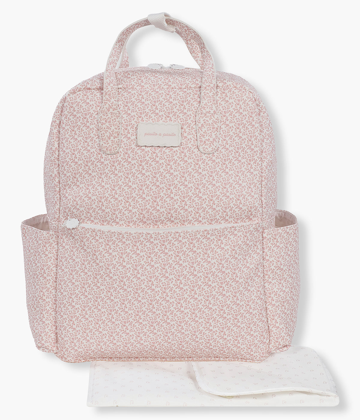 Vista frontal da mochila de maternidade Maison Tender Flowers da Pasito a Pasito. Fabricada em pele vegana com tratamento resistente à água, esta mochila branca com padrão floral rosa oferece um interior espaçoso e bem organizado, com bolso térmico para biberão, bolso plastificado para roupa húmida e vários compartimentos para manter todos os essenciais facilmente acessíveis. Inclui ainda um resguardo portátil.