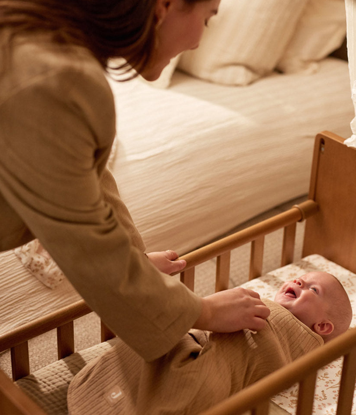 Swaddle wrap castanho marca Jollein com detalhes na malha para bebé e recém-nascido(a), 100% algodão. Composta por abas com velcro, este swaddle wrap oferece um ajuste suave e seguro, adaptando-se delicadamente ao corpo do bebé.