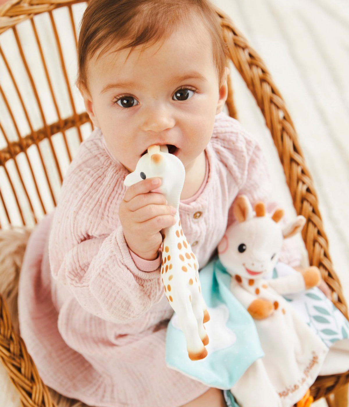 Bebé a brincar com conjunto mordedor sensorial Sophie La Girafe com doudou a combinar.