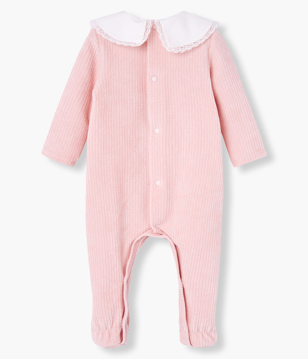 Babygrow em veludo canelado cor-de-rosa da Paz Rodríguez para bebé menina e recém-nascida. Delicado babygrow com gola bico cortada com renda detalha em pérola, dois botões madrepérola decorativos e medalha com logo da marca.