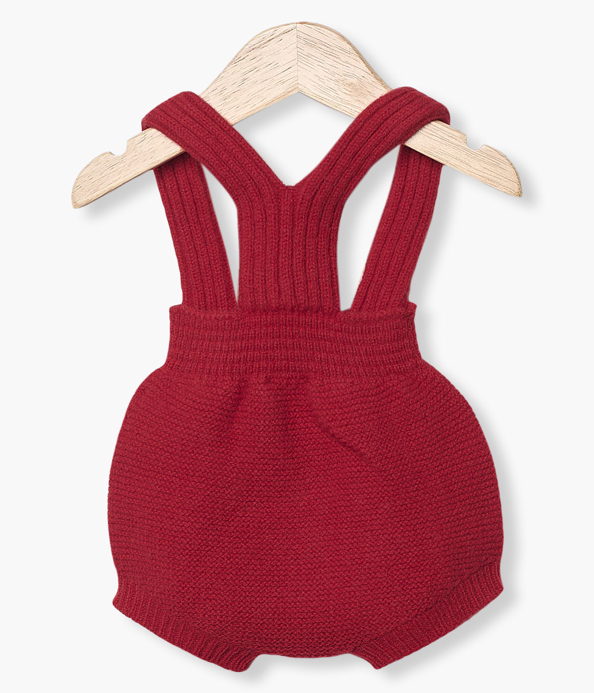 Fofo tricotado em lã merino vermelho da Wedoble para bebé e recém-nascido(a). Delicado fofo com dois bolsos decorativos na frente e abertura nas alças com botões de madeira.