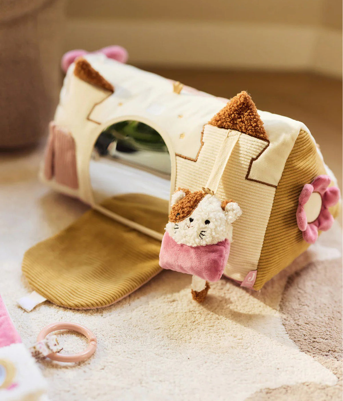 Triângulo de Atividades Flower Fairies da Jollein para bebé menina. Brinquedo sensorial em forma de castelo, com espelho, portas interativas, mordedor, texturas e elementos sonoros, perfeito para estimular o desenvolvimento do bebé enquanto brinca confortavelmente no parque ou tapete.