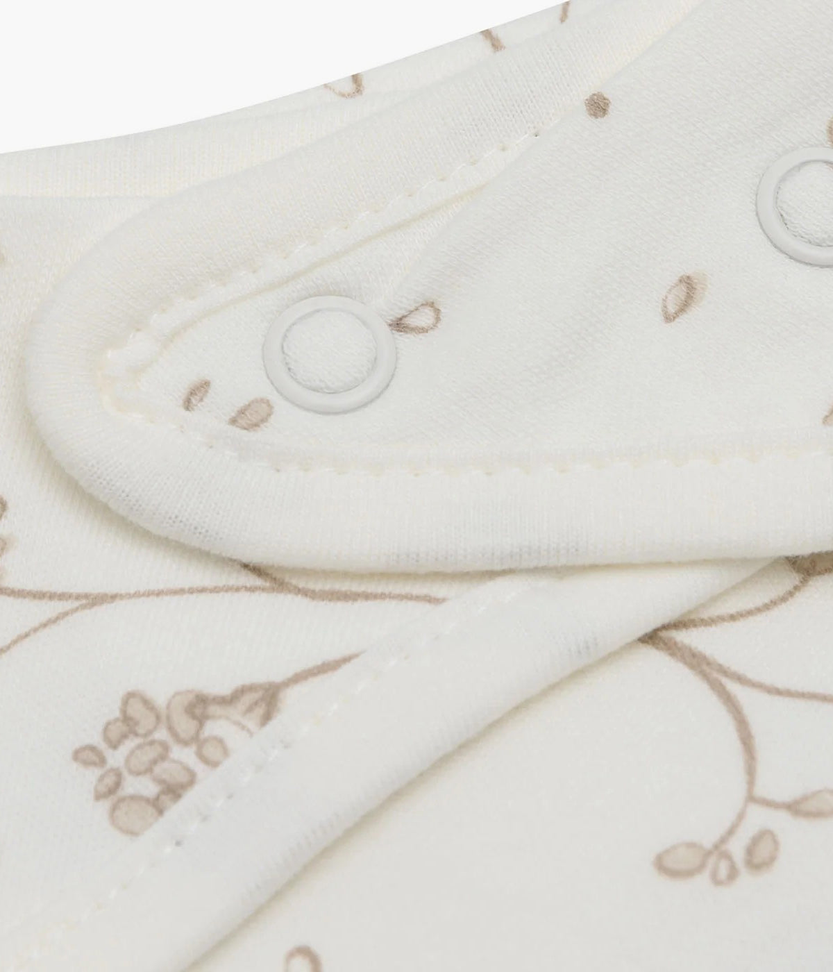 Pack composto por duas bandanas em algodão pérola com padrão dentes-de-leão em tons de bege para bebé e recém-nascido(a). Fecho com molas de pressão em duas medidas.