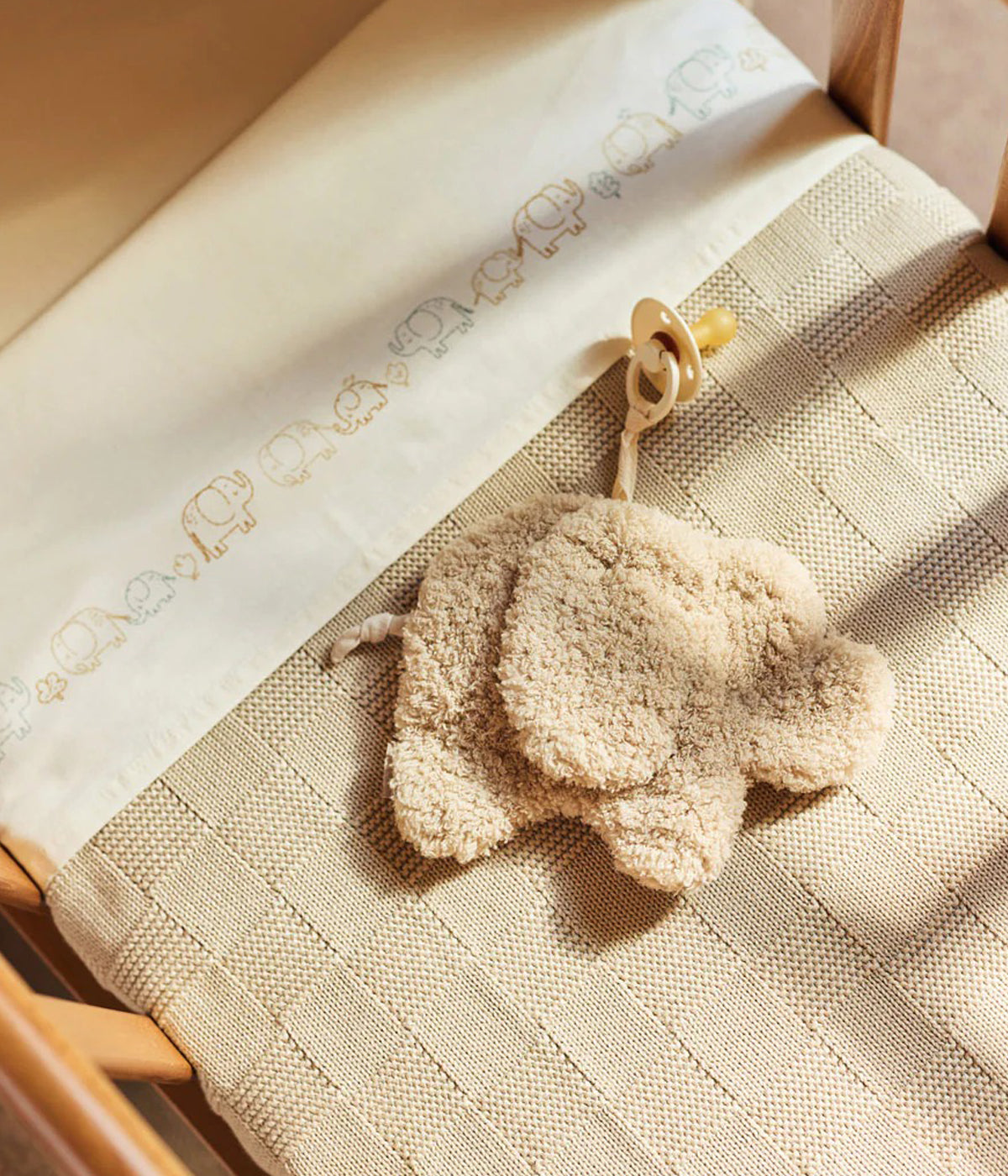 Doudou Prende Chupetas Elephant Tales da Jollein. Em tons de bege, super macio e adorável, este doudou com forma de elefante e laço para prender a chupeta é um companheiro prático e irresistível para o bebé.