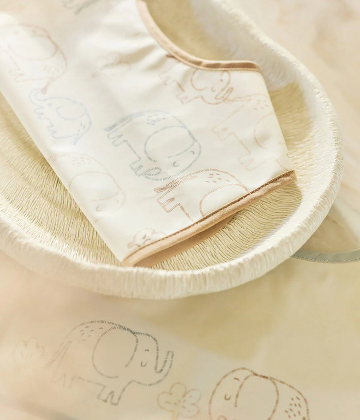 Conjunto de duas babetes impermeáveis pérola com padrão elefantes em tons de azul e bege da Jollein para bebé e recém-nascido(a). Babetes impermeáveis com bolso perfeitas para manter o bebé limpo enquanto aprende a beber e comer sozinho.