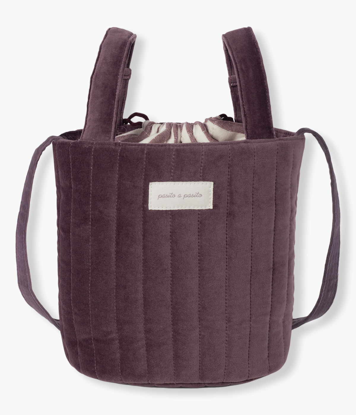 Bolsa Bucket Pasito a Pasito Cherry Velvet com um elegante exterior em veludo de algodão impermeável em tons de bordô. O seu formato tipo balde maximiza o espaço interior, permitindo uma organização prática e um acesso rápido aos essenciais do(a) bebé.