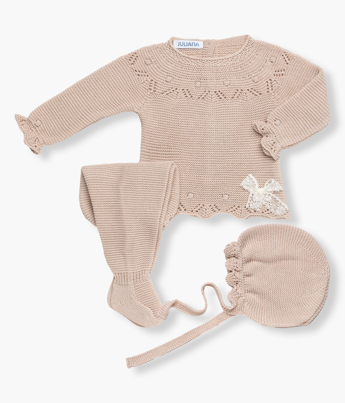 Vista de frente do conjunto em malha bege da Juliana para bebé menina e recém‑nascida, composto por camisola, calças e touca. Camisola com detalhes perfurados nos contornos e laço em renda pérola. Touca com pequeno rebordo ondulado a toda a volta. Calças lisas com pés.