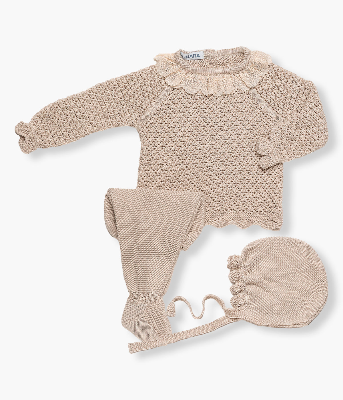Vista de frente do conjunto em malha bege da Juliana para bebé menina e recém‑nascida, composto por camisola, calças e touca. Camisola com gola folho em renda detalhada, detalhes perfurados na malha e rebordo ondulado nos contornos. Touca e calças com pés a combinar.
