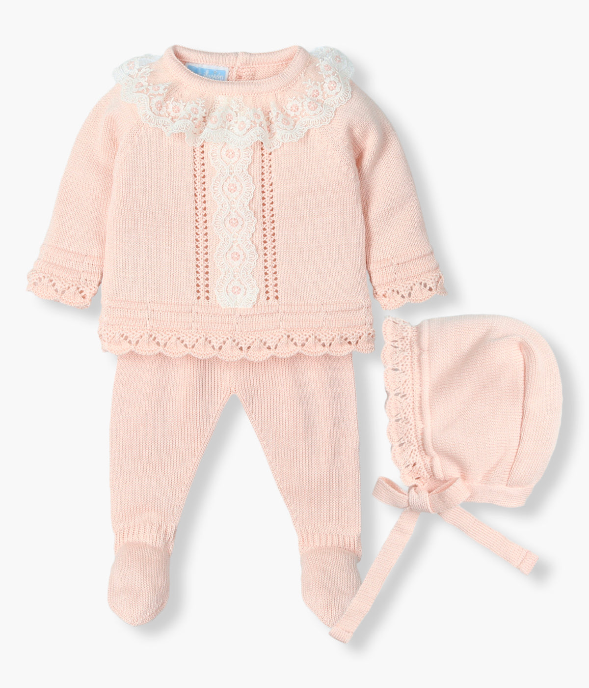 Conjunto de 3 peças em malha nude da Mac Ilusión composto por camisola, calças e touca para bebé menina e recém-nascida. Camisola com gola folho e detalhe na frente em renda detalhada e pormenores perfurados na malha nos contornos. Touca com rebordo perfurado a combinar. Calças lisas com pés.