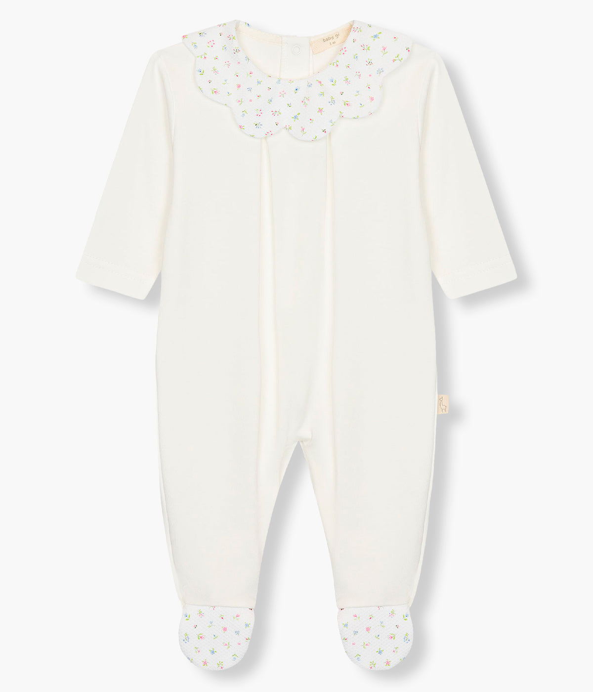 Vista da frente do babygrow em algodão pérola da Baby Gi para bebé menina e recém-nascida. Gola ondulada em tecido piquet com padrão floral. Abertura com molas de pressão nas costas e entrepernas.