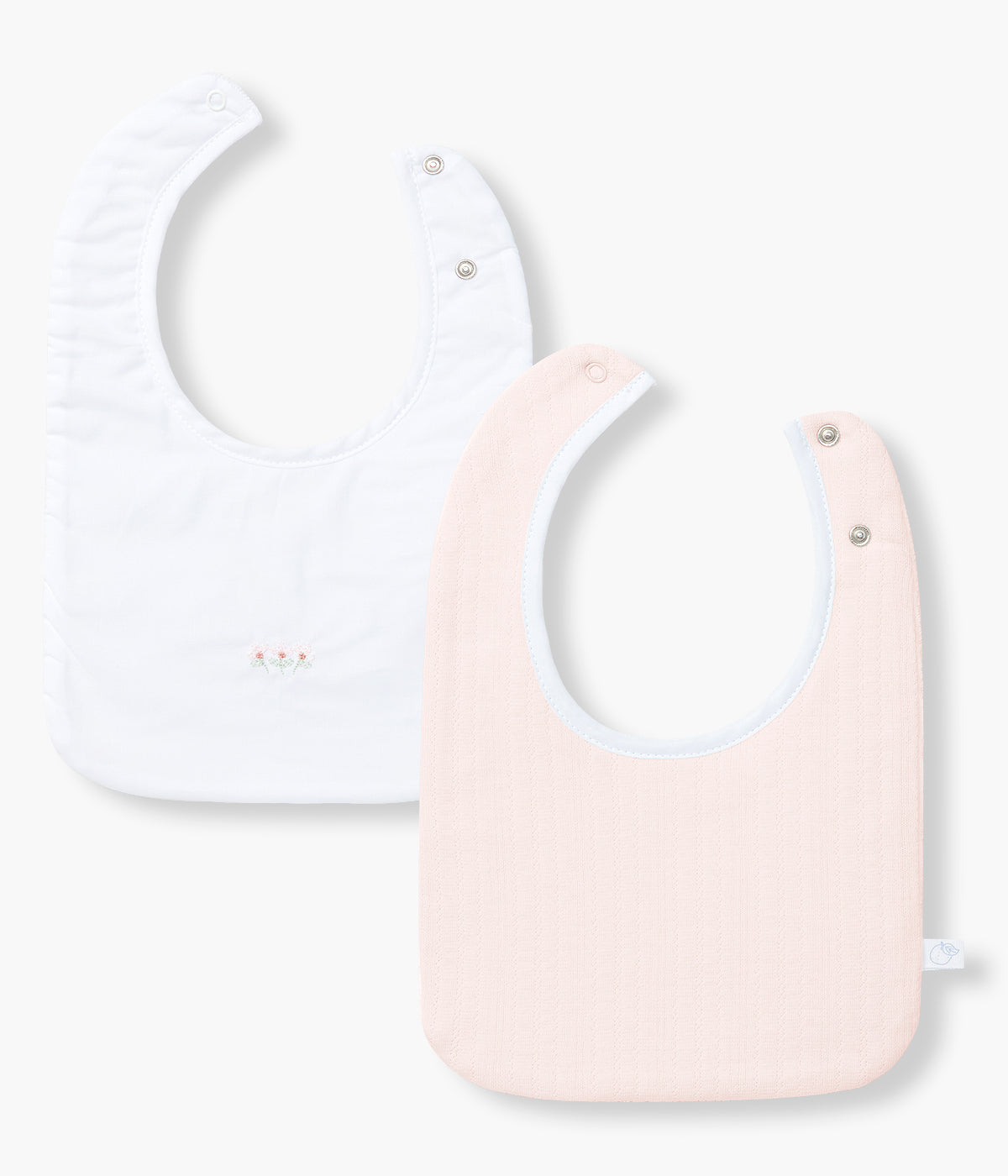 Vista de frente do pack de 2 babetes com turco impermeável da Laranjinha para bebé menina e recém-nascida. Uma babete em algodão orgânico rosa com detalhes na malha e outra babete branca com pequenas flores bordadas.