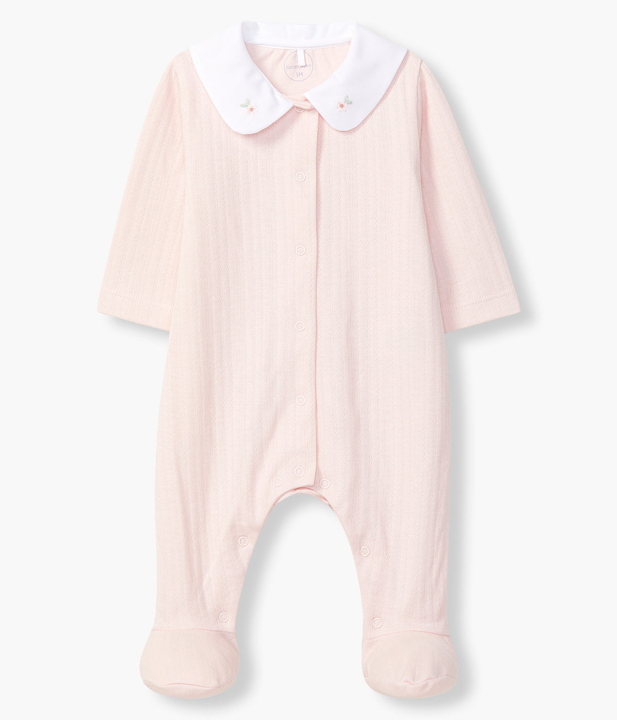 Vista de frente do babygrow em algodão orgânico rosa da Laranjinha para bebé menina e recém-nascida. Gola redonda branca cortada com pequenas flores bordadas e detalhes na malha. Abertura na frente e entrepernas.