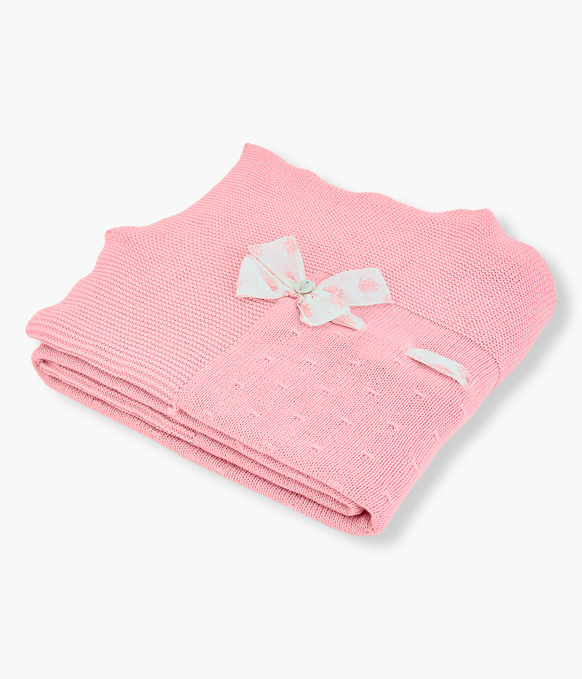Manta em malha de algodão rosa da Paz Rodríguez para bebé menina e recém-nascida. Elegante manta com detalhes perfurados, rebordo ondulado e laço no canto com padrão floral.