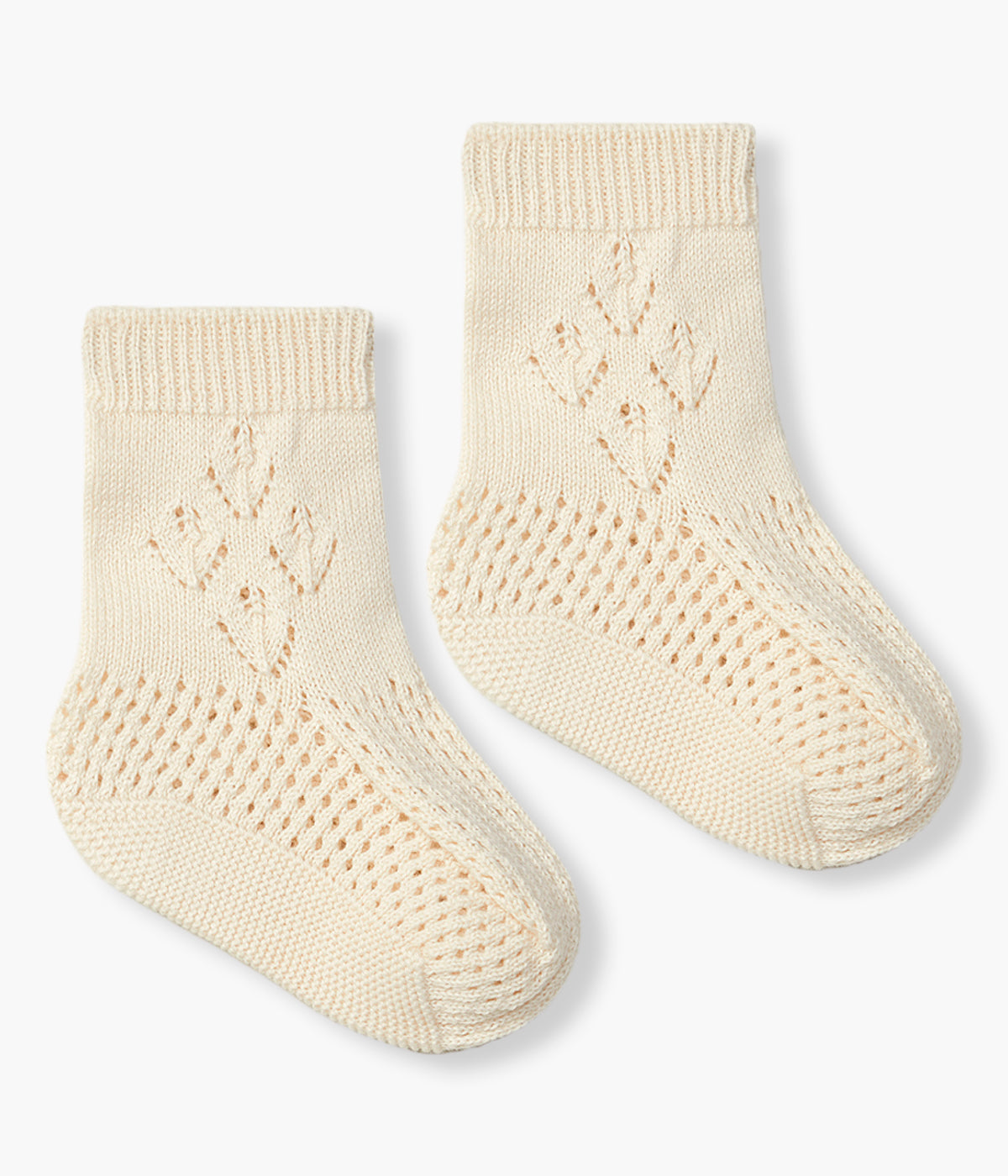 Vista de frente do par de carapins em malha de algodão orgânico bege da Wedoble para bebé e recém-nascido(a). Carapins com formato de bota com detalhes perfurados.