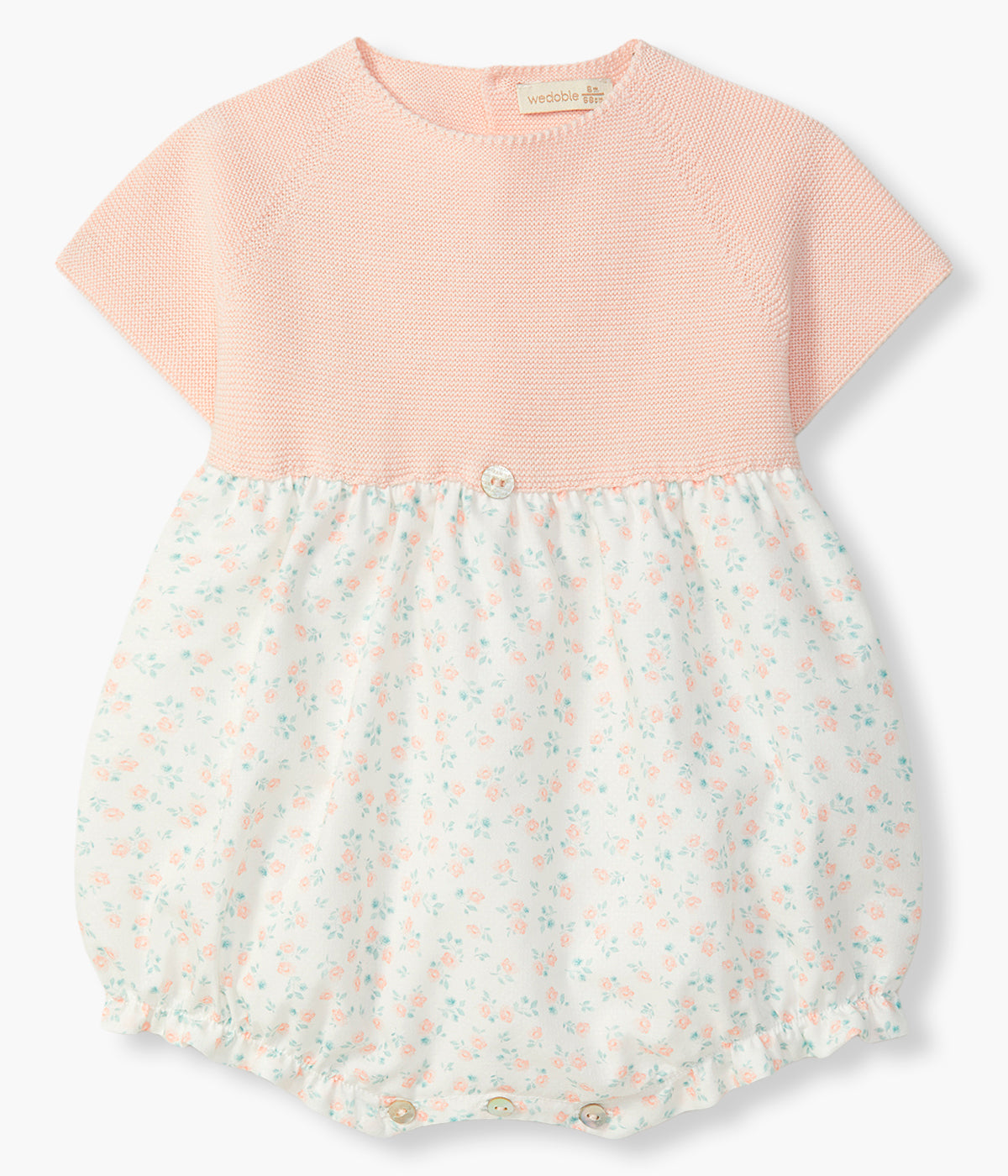 Vista de frente do fofo da Wedoble para bebé menina e recém-nascida. Elegante fofo com parte superior em malha de algodão orgânico rosa e parte inferior em tecido efeito balão em algodão com padrão floral em fundo branco.