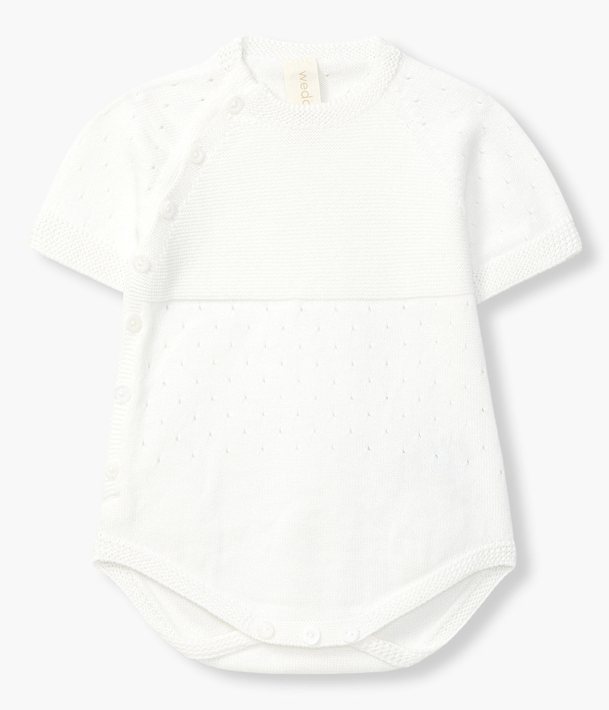 Vista de frente do fofo em malha de algodão orgânico pérola da Wedoble para bebé e recém-nascido(a). Suave e delicada malha com detalhes perfurados. Abertura na lateral e entrepernas.