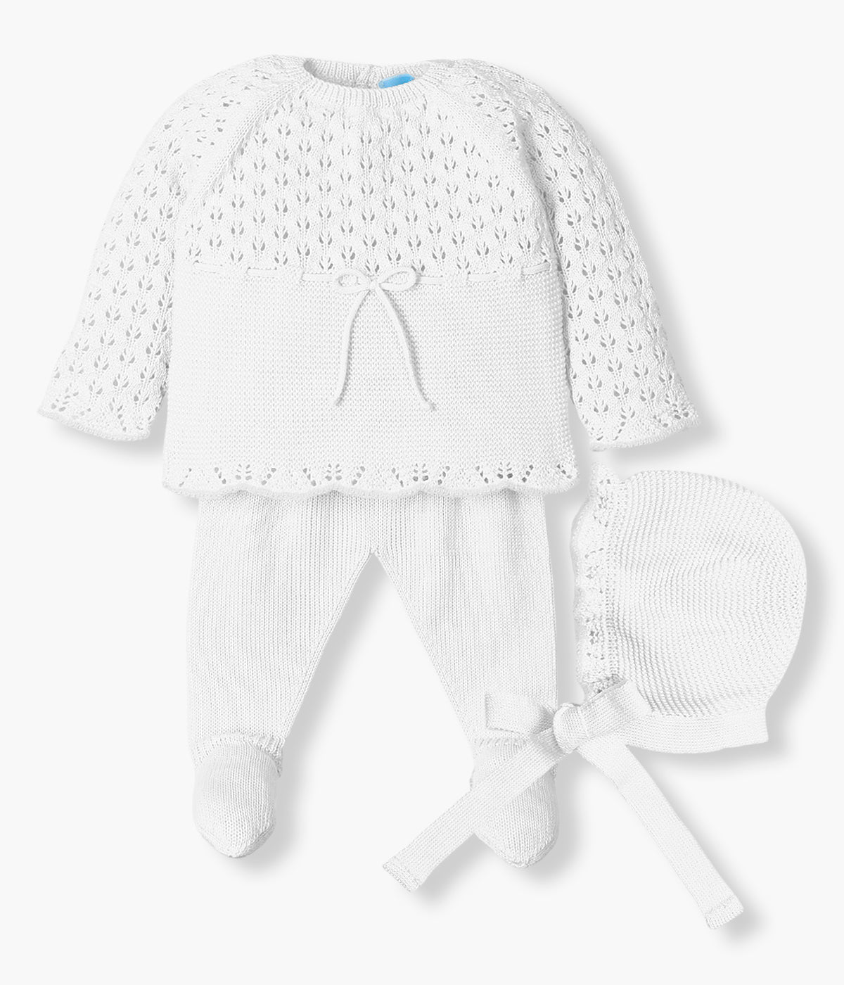Vista de frente do conjunto de 3 peças em malha branco da Mac Ilusión composto por camisola, calças e touca para bebé e recém-nascido(a). Camisola com detalhes perfurados, contornos ondulados e laço na frente. Touca a combinar. Calças lisas com pés.