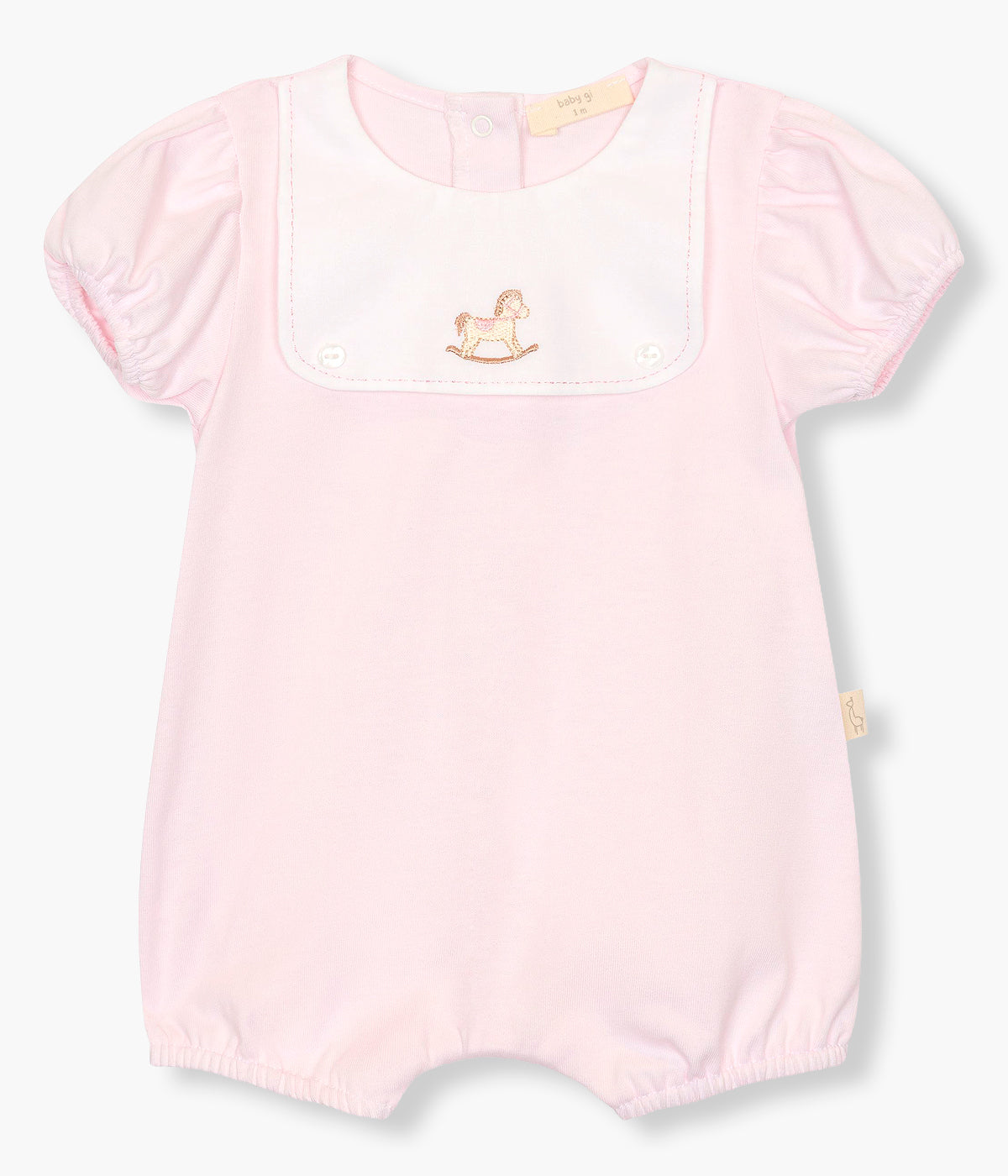 Vista frontal do fofo em algodão rosa da Baby Gi para bebé menina e recém-nascida. Peitilho com detalhe em tecido com cavalo de madeira bordado e dois botões madrepérola decorativos. Abertura com molas de pressão nas costas e entrepernas.