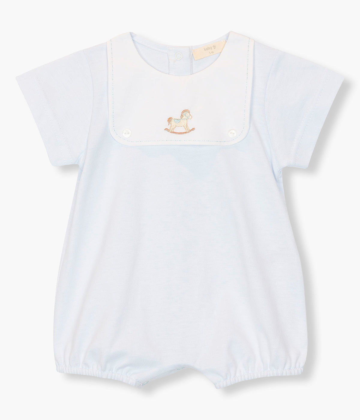 Vista de frente do fofo em algodão azul da Baby Gi para bebé menino e recém-nascido. Peitilho com detalhe em tecido com cavalo de madeira bordado e dois botões madrepérola decorativos. Abertura com molas de pressão nas costas e entrepernas.