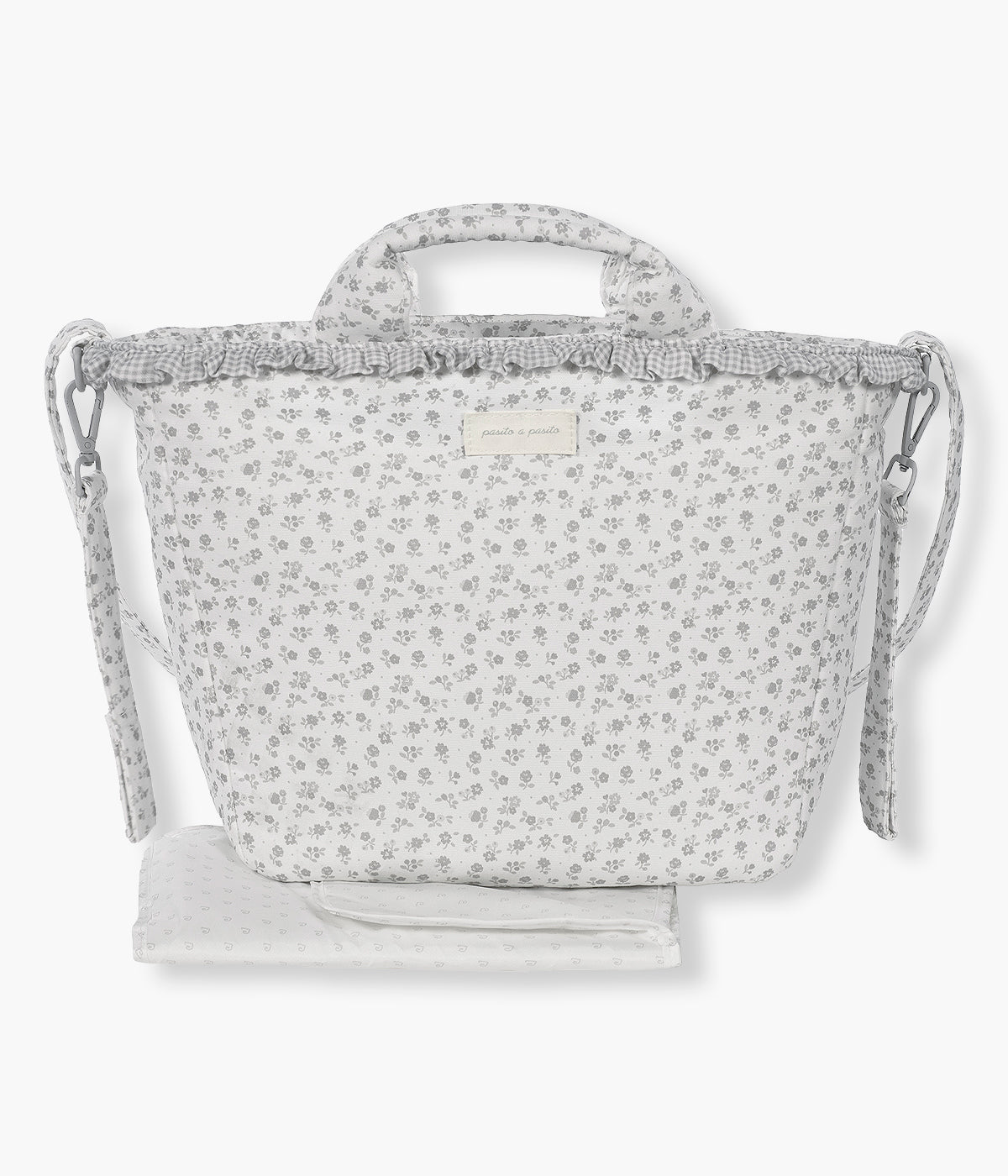 Vista de frente da mala de Maternidade Little Bloom Flowers da Pasito a Pasito. Prática mala de maternidade que combina elegância com um padrão floral cinza e uma grande capacidade para transportar tudo o que a bebé precisa. Confeccionada em loneta 100% algodão com tratamento resistente à água, esta mala inclui vários compartimentos interiores e um prático resguardo portátil.