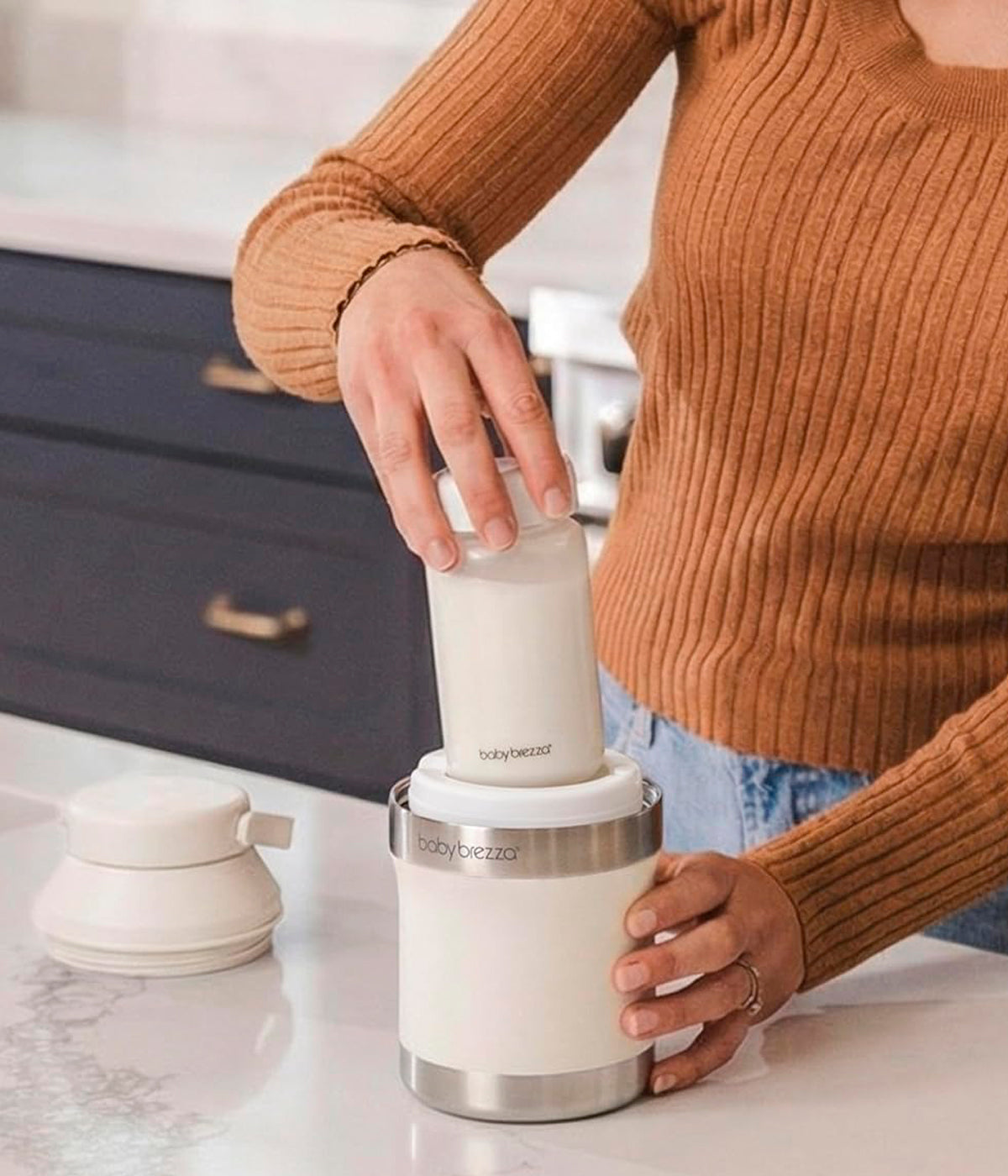 Vista em utilização do refrigerador portátil de leite Materno Baby Brezza All-day Breastmilk Portable Cooler. Prática garrafa térmica com capacidade de 300ml que mantém o leite materno frio até 24 horas, garantindo conservação segura durante todo o dia. Prático, compacto e ideal para mães que extraem leite em casa, no trabalho ou em viagem.