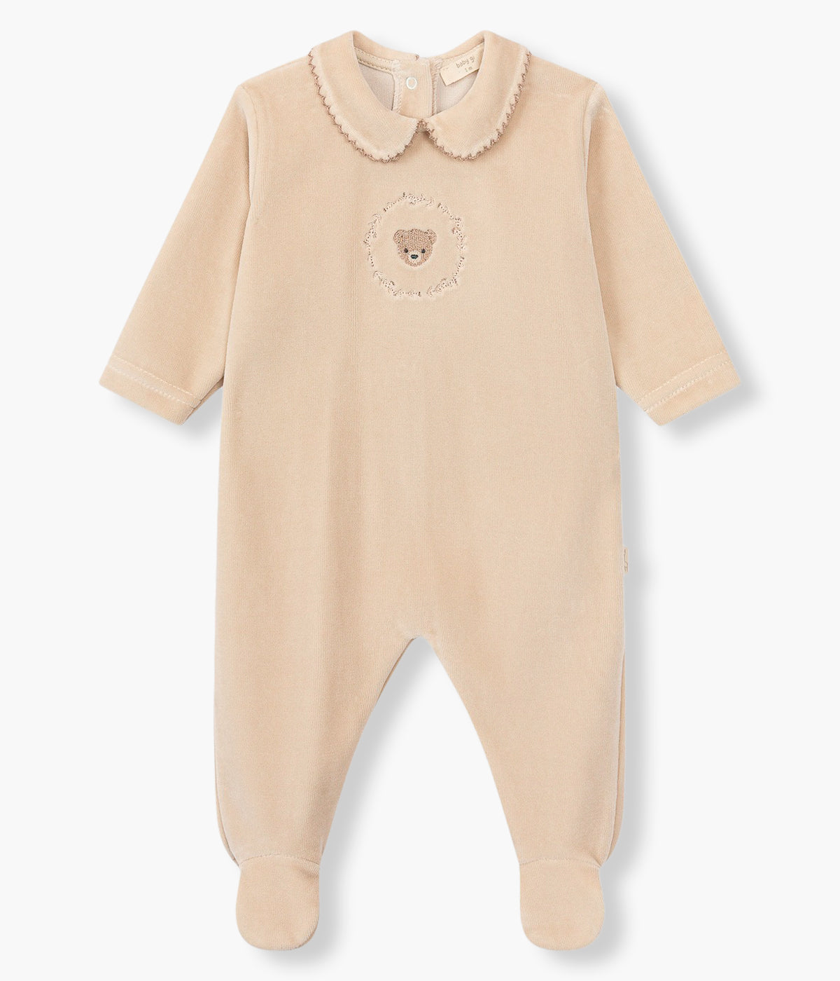 Vistya frontal do babygrow em veludo bege da Baby Gi para bebé e recém-nascido(a). Gola redonda cortada com picueta castanha. Urso com coroa de ramos bordado no peito. Abertura com molas de pressão nas costas e entrepernas.