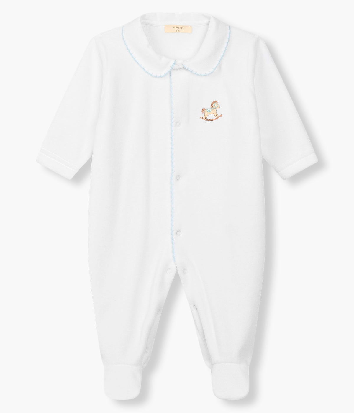 Vista frontal do babygrow em veludo branco da Baby Gi para bebé menino e recém-nascido. Gola folho e abertura com picueta em azul na abertura. Cavalo bordado no peito. Abertura com molas de pressão na frente e entrepernas.