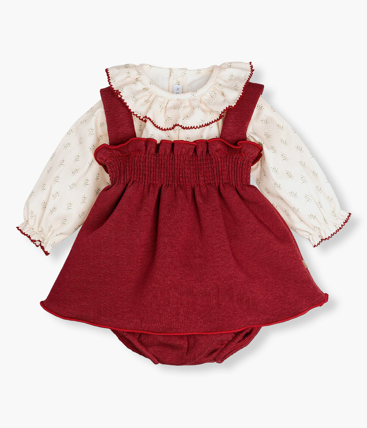 Vista frontal do conjunto de 3pc composto por vestido, blusa e tapa fraldas da Calamaro Baby para bebé menina e recém-nascida. Elegante vestido de alças e tapa fraldas em tecido polar bordô. Blusa em algodão com gola folho com padrão ramos verdes e contornos em bordô.