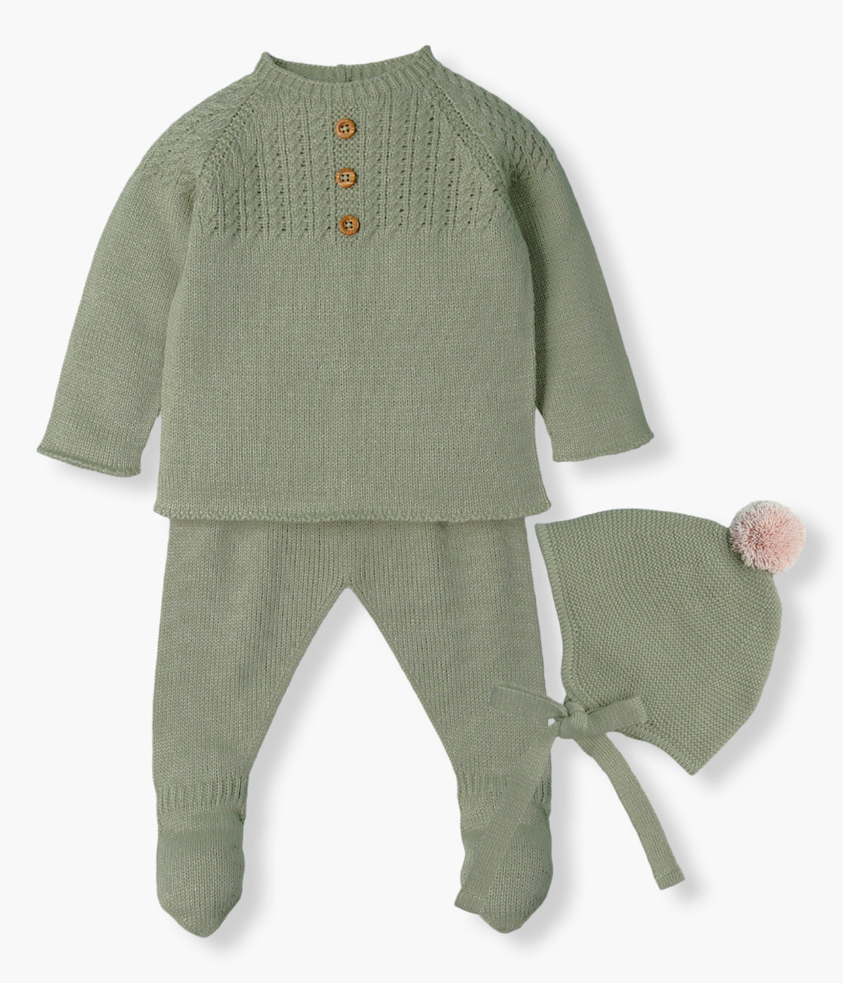Vista frontal do conjunto de 3pc em malha verde da Mac Ilusión para bebé e recém-nascido(a). Camisola com botões de madeira decorativos e detalhes na malha. Calças com pés. Gorro com pompom bege e tiras para atar no queixo.