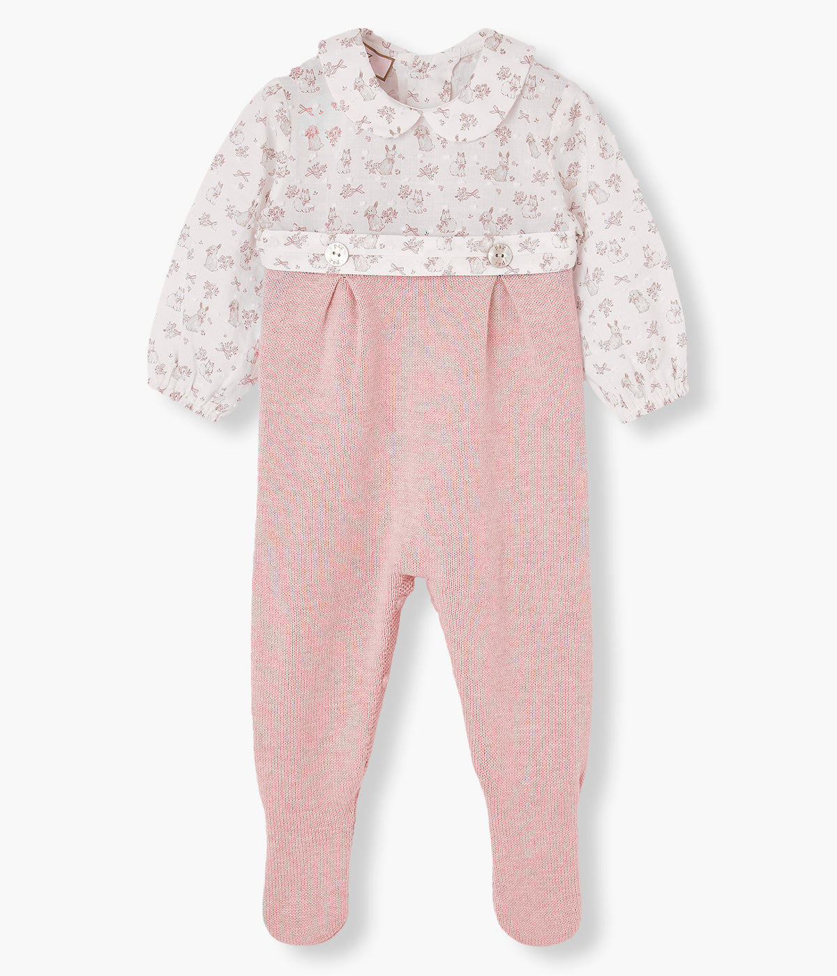 Vista frontal do babygrow da Paz Rodríguez para bebé menina e recém-nascida. Parte superior em tecido plumeti branco com padrão coelhos, gola redonda cortada e dois botões de madrepérola. Parte inferior em malha de algodão e caxemira rosa.
