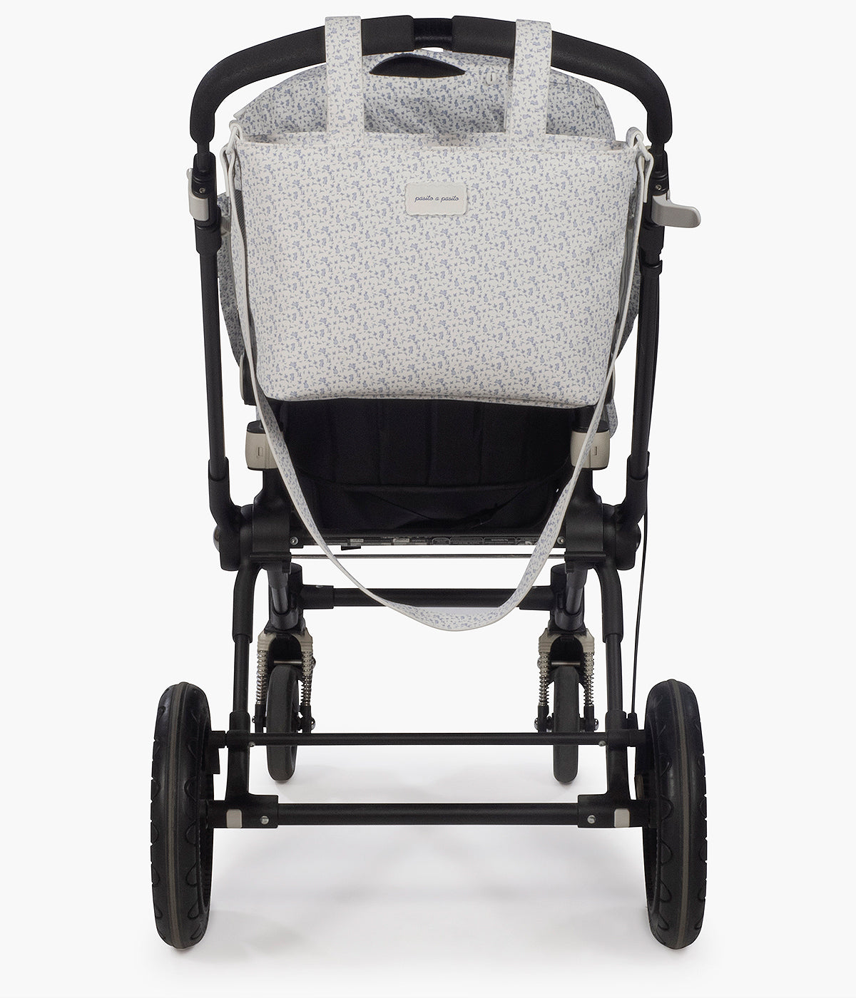 Vista pendurada no carrinho da bolsa de passeio Maison Tender da Pasito a Pasito com o padrão Rabbits. Prática bolsa de design elegante com um padrão coelhos azuis e com um formato compacto e funcional para os passeios com o bebé. Fabricada em pele vegana, com tratamento waterproof, possui vários bolsos interiores e um bolso térmico para manter os essenciais organizados.