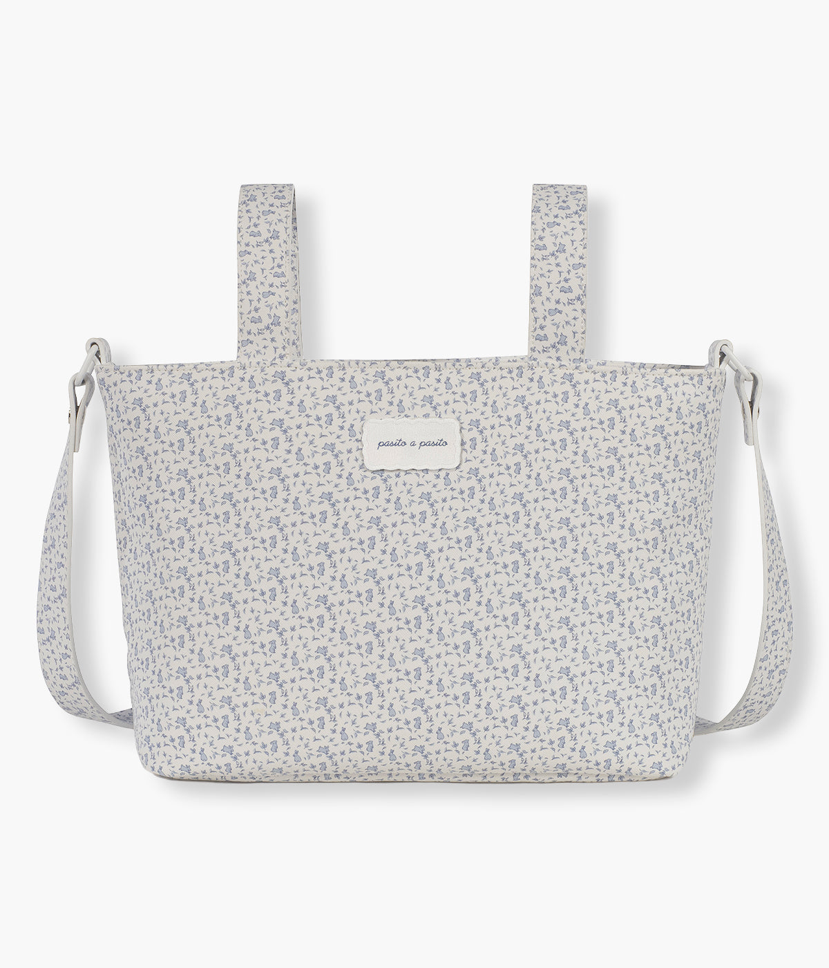Vista frontal da bolsa de passeio Maison Tender da Pasito a Pasito com o padrão Rabbits. Prática bolsa de design elegante com um padrão coelhos azuis e com um formato compacto e funcional para os passeios com o bebé. Fabricada em pele vegana, com tratamento waterproof, possui vários bolsos interiores e um bolso térmico para manter os essenciais organizados. Pode ser transportada ao ombro ou facilmente presa ao carrinho através das alças adicionais incluídas.