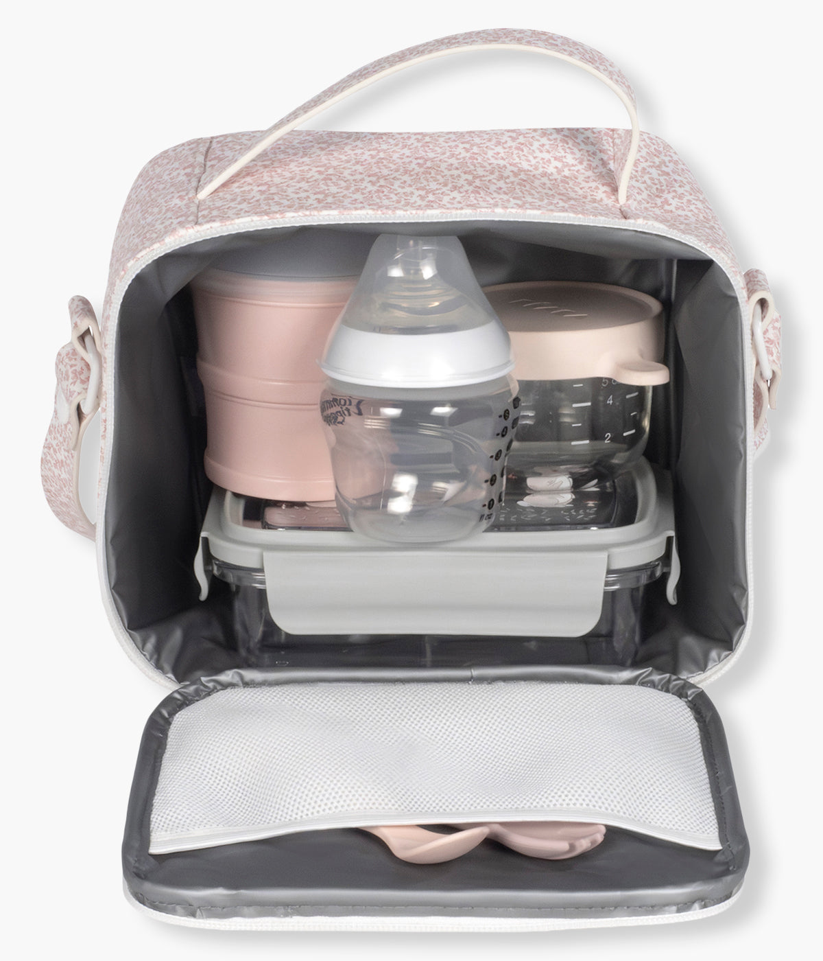 Vista frontal e aberta da bolsa térmica Maison Tender da Pasito a Pasito. Prática bolsa que permite transportar a comida e as bebidas da bebé ajudando a conservar a temperatura durante mais tempo. Fabricada em pele vegana com padrão flores em tons de rosa, possui um interior isotérmico espaçoso, abertura ampla com fecho de correr e um prático bolso de rede na tampa. A pega de mão e a alça de ombro tornam-na fácil de transportar em passeios, viagens, creche ou no dia a dia.