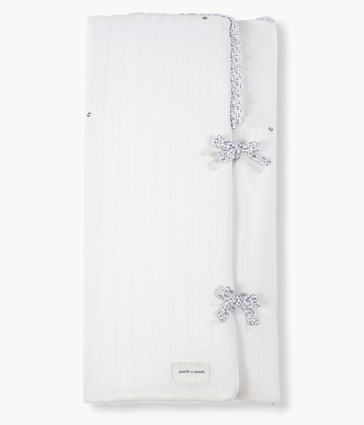 Vista frontal do saco Manta Maison Tender da Pasito a Pasito. Elegante saco manta com TOG 2.5 que proporciona uma envolvência suave e confortável nos primeiros meses do bebé. Fabricado em 100% algodão, combina um exterior branco com delicada textura de riscas verticais e um interior em musselina lisa de algodão. O formato tipo envelope, os laços de ajuste e o fecho de correr na zona dos pés ajudam a manter o bebé aconchegado, podendo ainda ser completamente aberto e utilizado como manta.