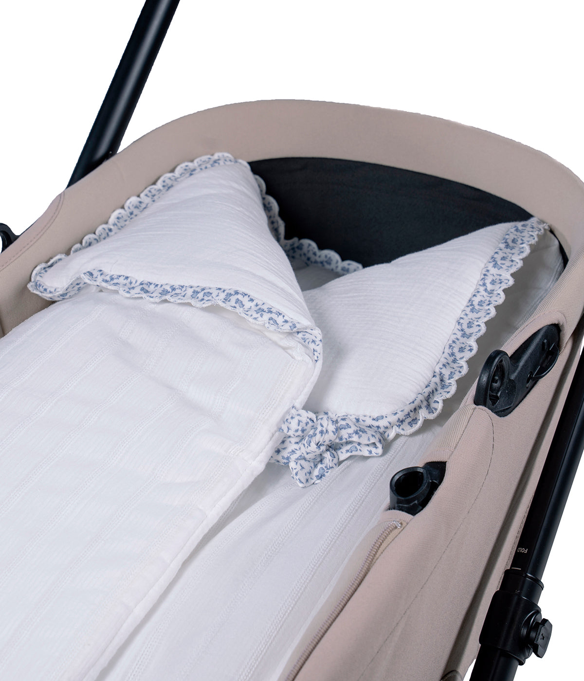 Vista detalhada do saco Manta Maison Tender da Pasito a Pasito. Elegante saco manta com TOG 2.5 que proporciona uma envolvência suave e confortável nos primeiros meses do bebé. Fabricado em 100% algodão, combina um exterior branco com delicada textura de riscas verticais e um interior em musselina lisa de algodão. O formato tipo envelope, os laços de ajuste e o fecho de correr na zona dos pés ajudam a manter o bebé aconchegado, podendo ainda ser completamente aberto e utilizado como manta.