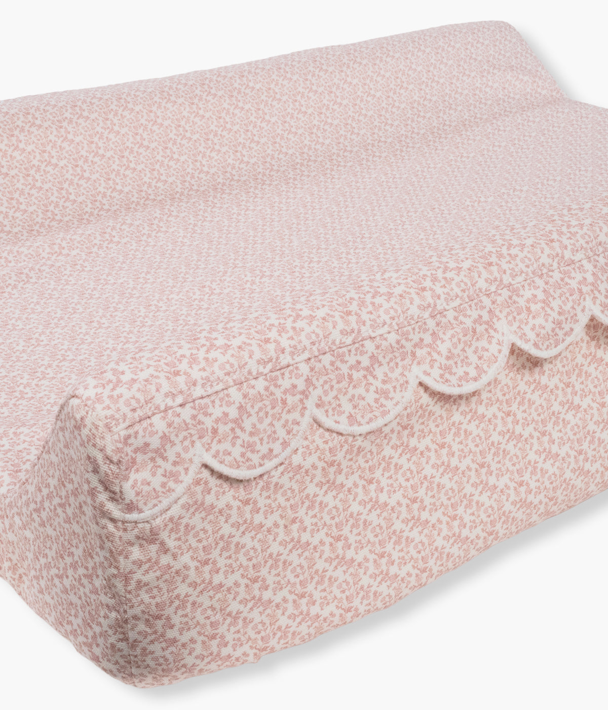 Vista lateral do trocador de fraldas Maison Tender da Pasito a Pasito. Superfície confortável e estável para as trocas diárias da bebé com padrão flores rosa. Possui interior em espuma viscoelástica, capa impermeável e removível em 100% algodão e base antiderrapante para maior estabilidade. Com medidas de 70 × 50 cm, inclui ainda um pequeno muda-fraldas adicional e cumpre a norma EN 12221 para muda-fraldas de uso doméstico.