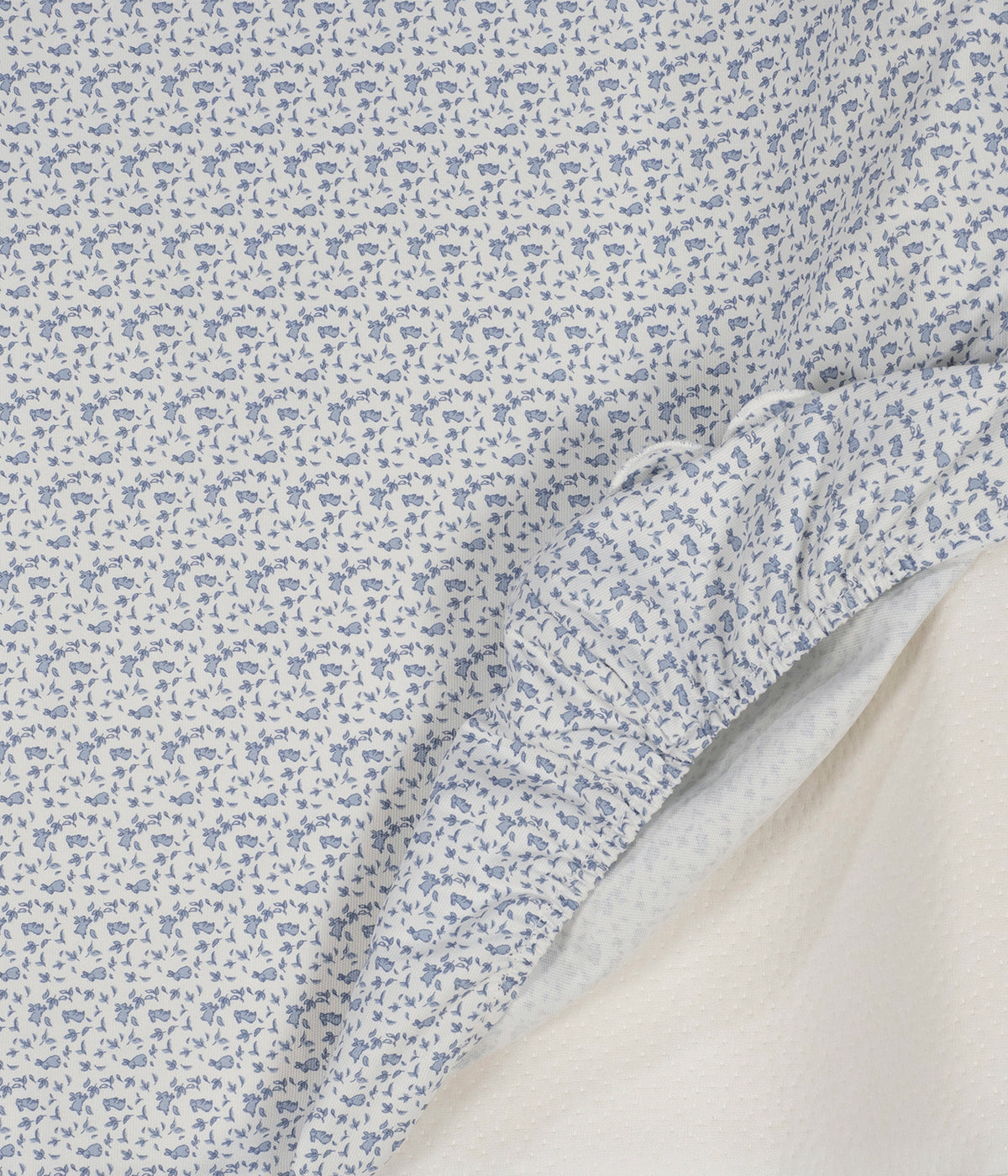 Vista detalhada do trocador de Fraldas Maison Tender da Pasito a Pasito. Prático trocador com elegante padrão coelhos azuis que oferece um espaço confortável e seguro para mudar a fralda do bebé em casa. Com espuma viscoelástica, base antiderrapante e capa removível impermeável, combina funcionalidade, higiene e um design delicado que harmoniza com o quarto do bebé.