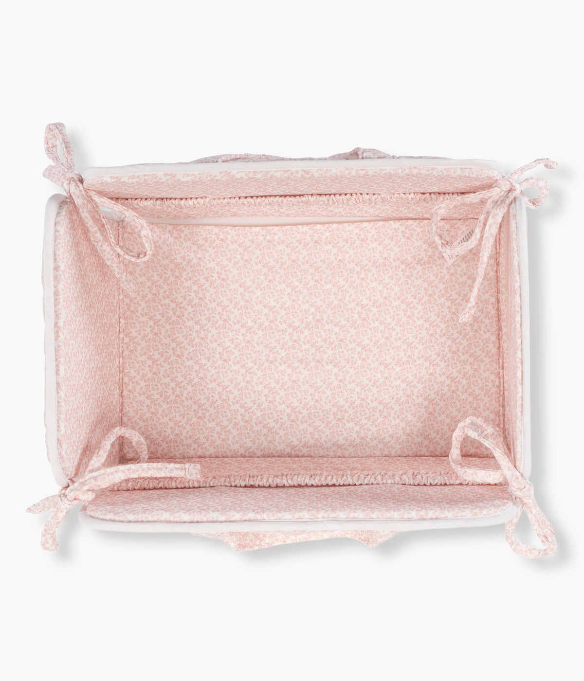 Vista superior da cesta organizadora Maison Tender da Pasito a Pasito. Elegante cesta que ajuda a manter os essenciais da bebé organizados e sempre à mão. Fabricada em 100% algodão, possui um formato leve e estruturado, ideal para colocar junto ao muda-fraldas, sobre a cómoda ou numa prateleira. O delicado padrão de flores em tons de rosa combina funcionalidade com o estilo suave e elegante da coleção Maison Tender.