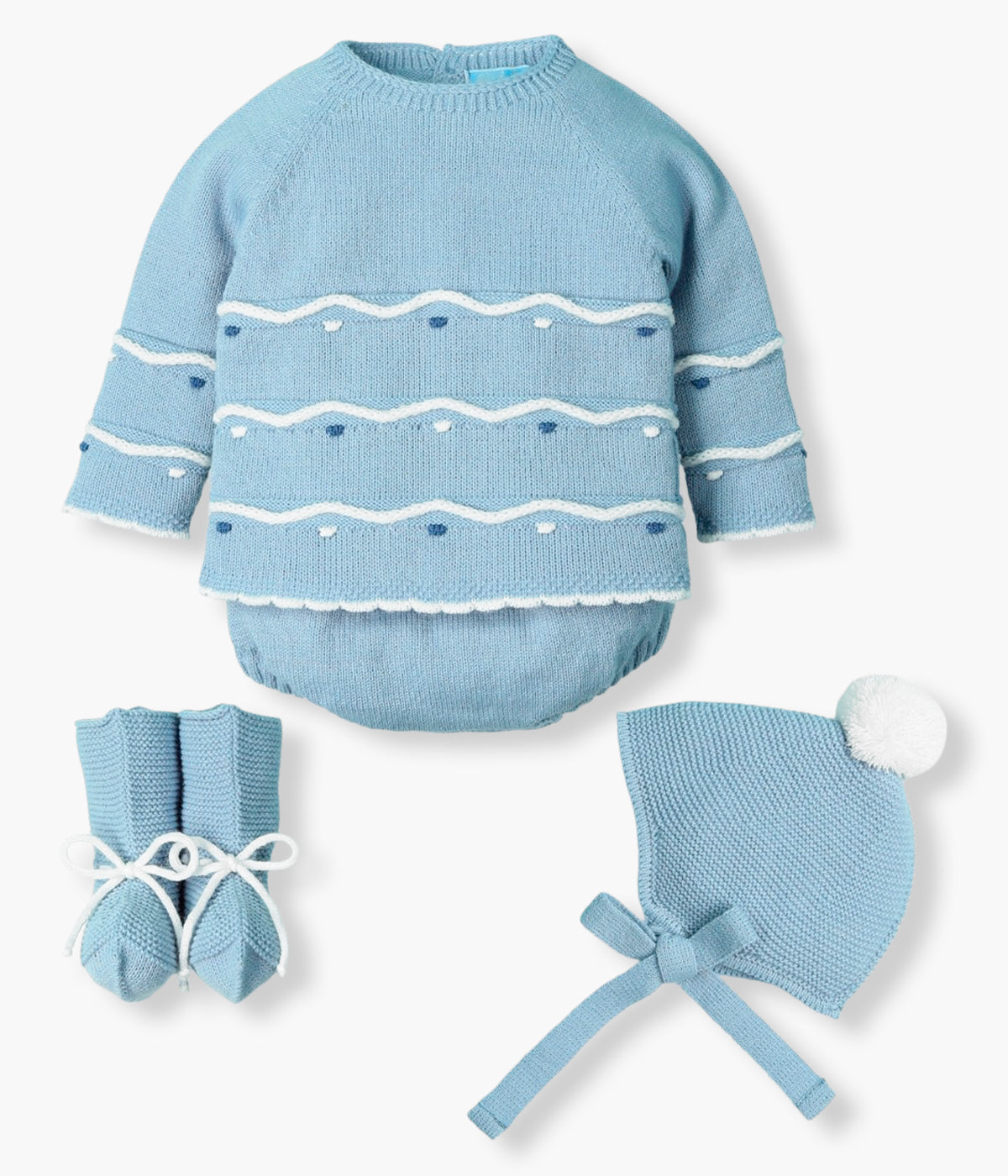 Vista de frente do conjunto de 4pc em malha da Mac Ilusión para bebé e recém-nascido(a). Camisola com detalhes com relevo em branco e tons de azul. Tapa fraldas liso. Gorro com pompom branco. Carapins tipo bota.