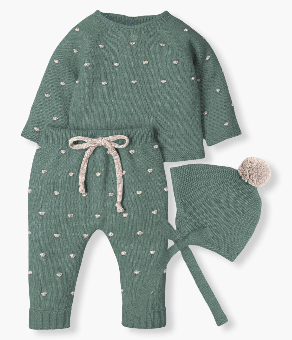 Vista frontal do conjunto de 3pc em malha verde da Mac Ilusión para bebé e recém-nascido(a). Camisola e calças com bolinhas com relevo bege. Camisola com bolso decorativo. Calças com cordão. Gorro com pompom e tiras.
