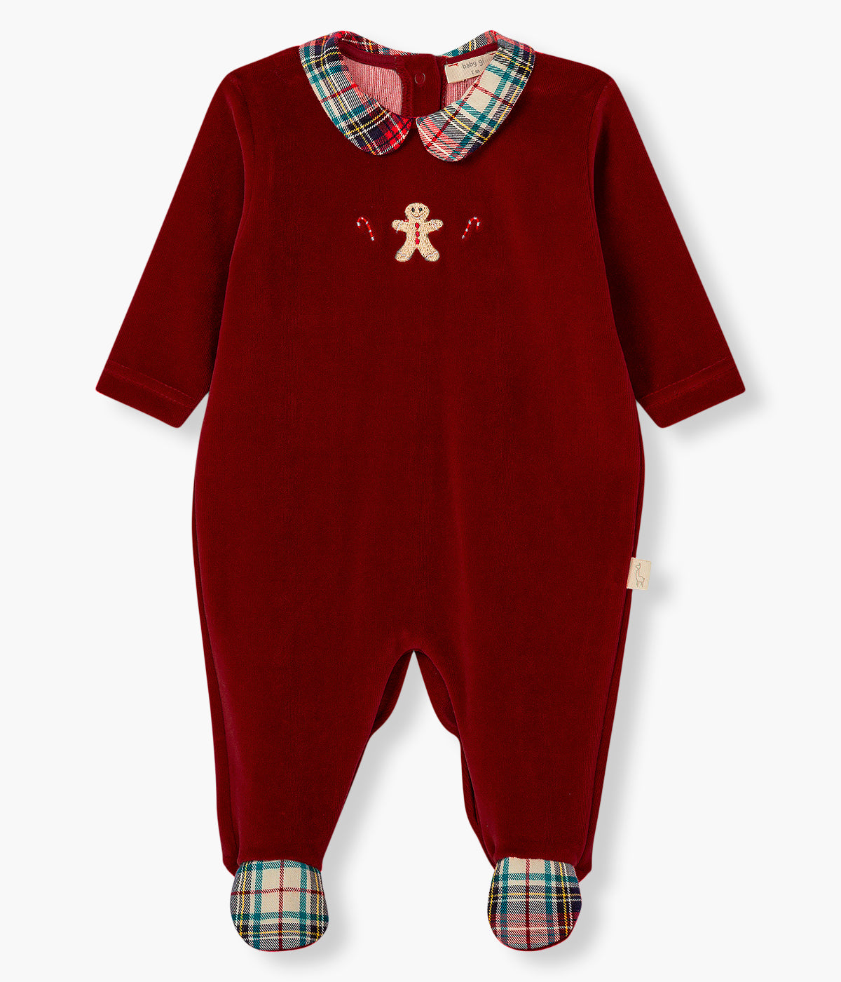 Vista frontal do babygrow em veludo vermelho-escuro da Baby Gi para bebé e recém-nascido(a). Gola redonda cortada e pés com padrão xadrez em tons de vermelho, verde e bege. Boneco de gengibre com duas bengalas no peito. Abertura nas costas e entrepernas.