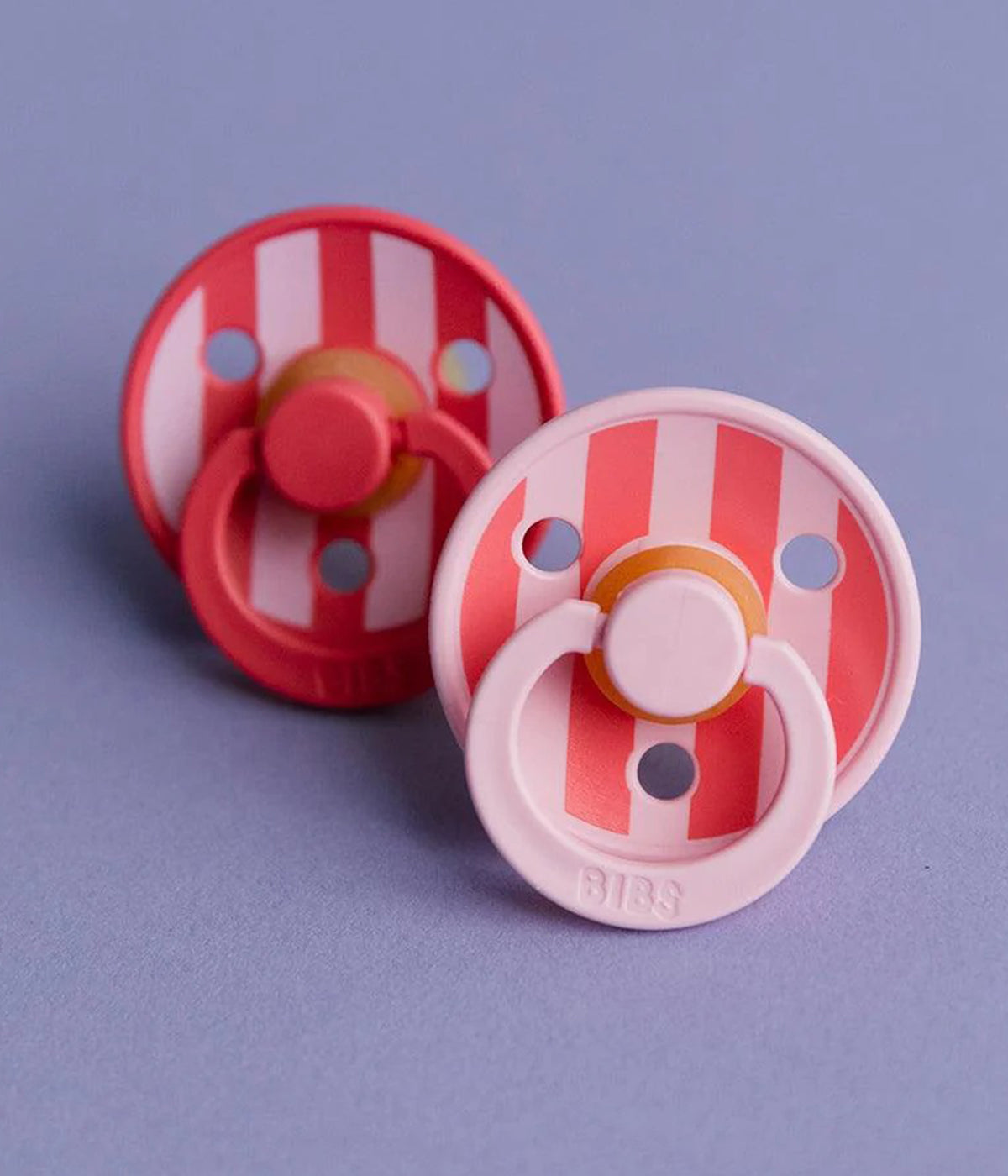 Pack de 2 chupetas Studio Colour Baby Pink Coral Mix com tetina redonda em borracha 100% natural. Conjunto composto por 1 chupeta rosa-claro (baby pink) e 1 chupeta coral, ambas decoradas com riscas.