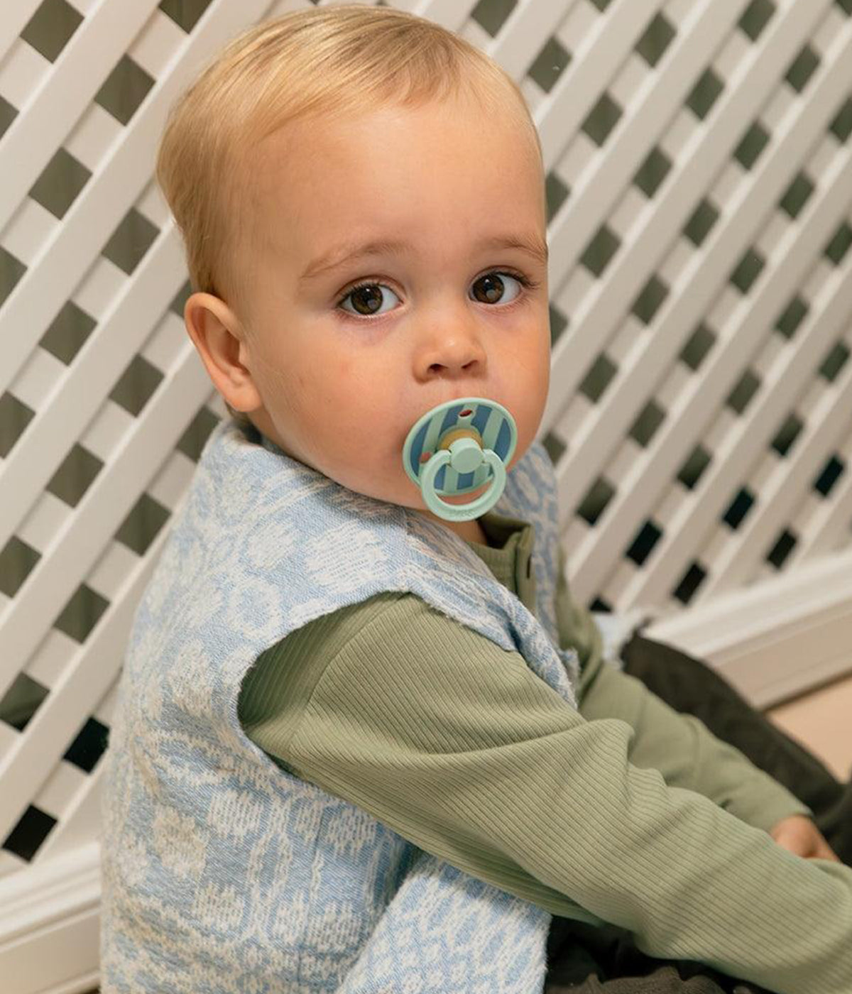 Bebé a usar 1 chupeta Bibs Studio Colour Nordic Mint Petrol Mix com tetina redonda em borracha 100% natural.