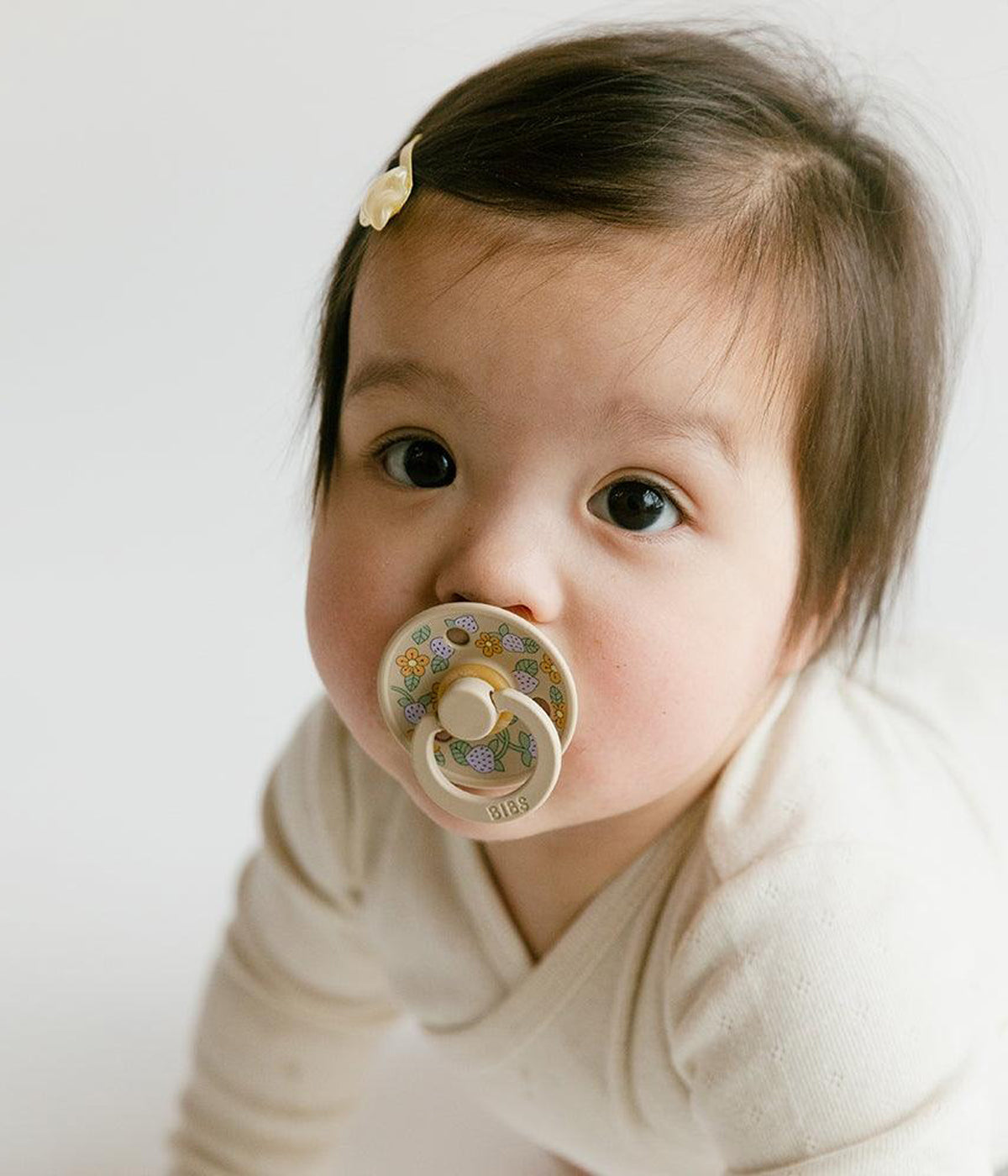 Pack de 2 chupetas Bibs x Liberty Colour Strawberries and Cream Ivory Mix com tetina redonda em borracha 100% natural. Conjunto composto por 1 chupeta marfim e 1 chupeta bege com padrão morangos e flores.