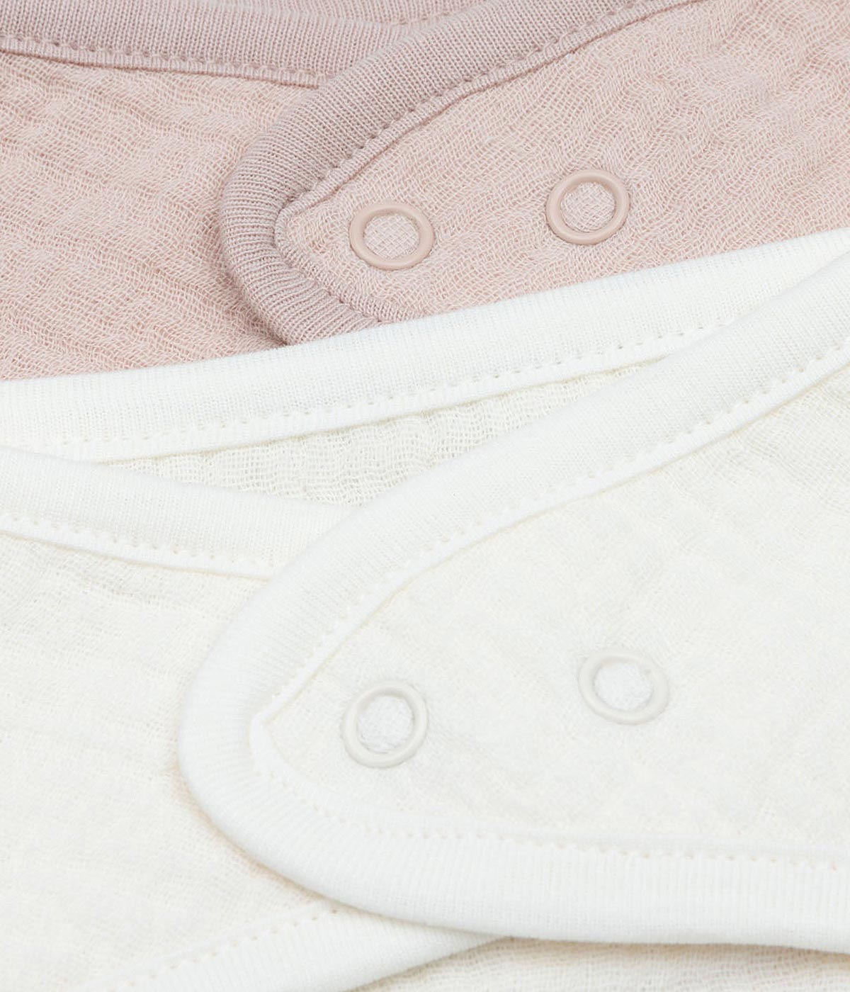 Pack composto por duas bandanas em algodão musselina rosa e pérola marca Jollein para bebé menina e recém-nascida. Fecho com molas de pressão.