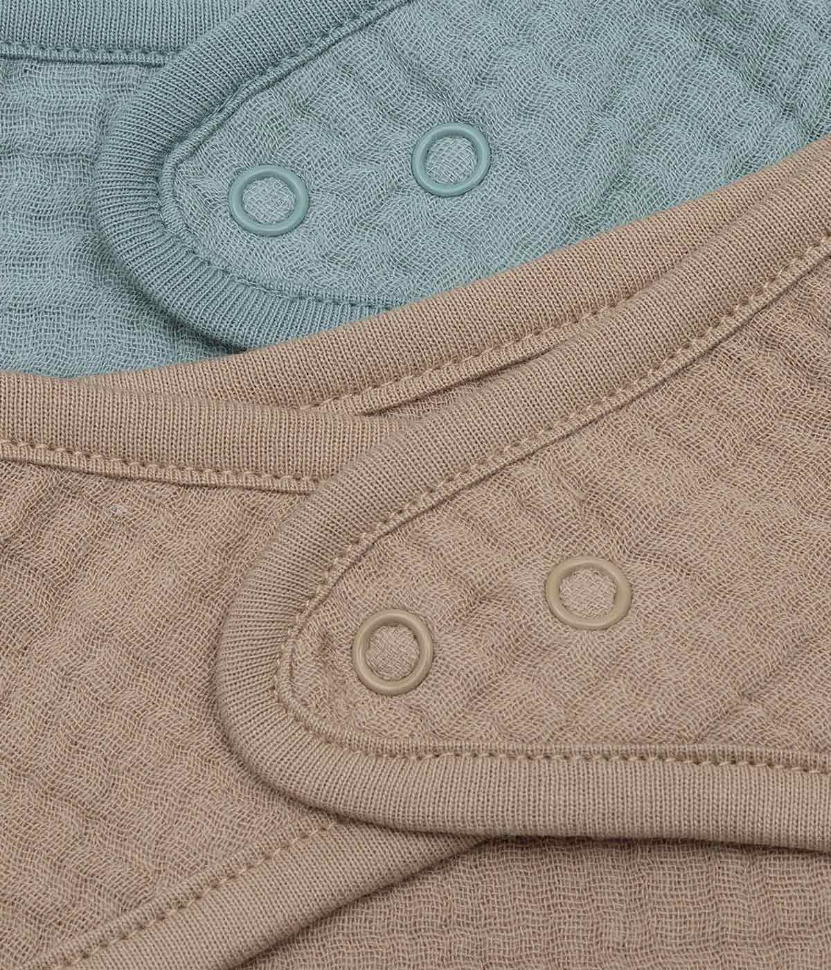 Pack composto por duas bandanas em algodão musselina castanho e verde da marca Jollein para bebé e recém-nascido(a). Fecho com molas de pressão.