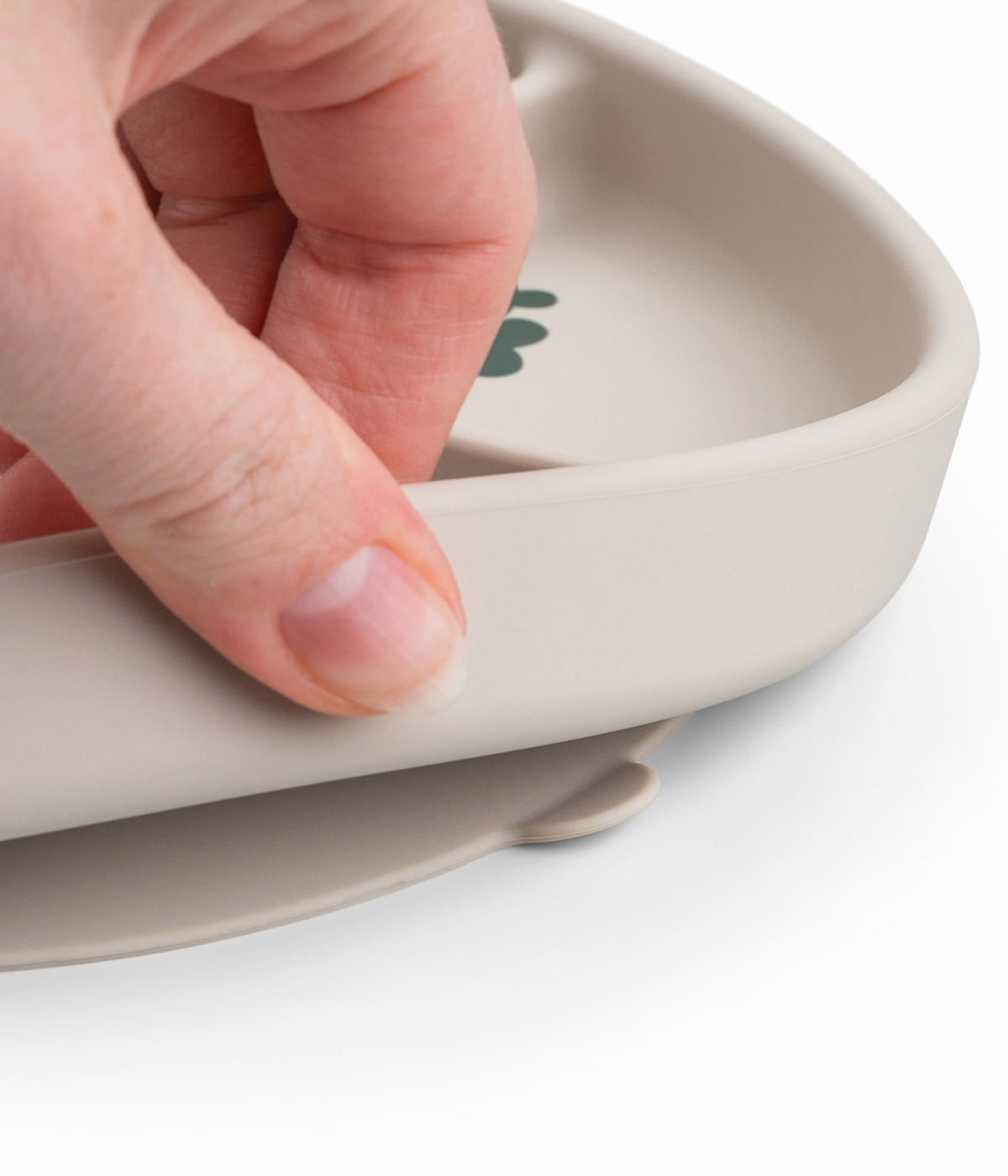 Detalhe da base de sucção antiderrapante do prato com divisórias em silicone de grau alimentar Done by Deer Tiny Farm bege.