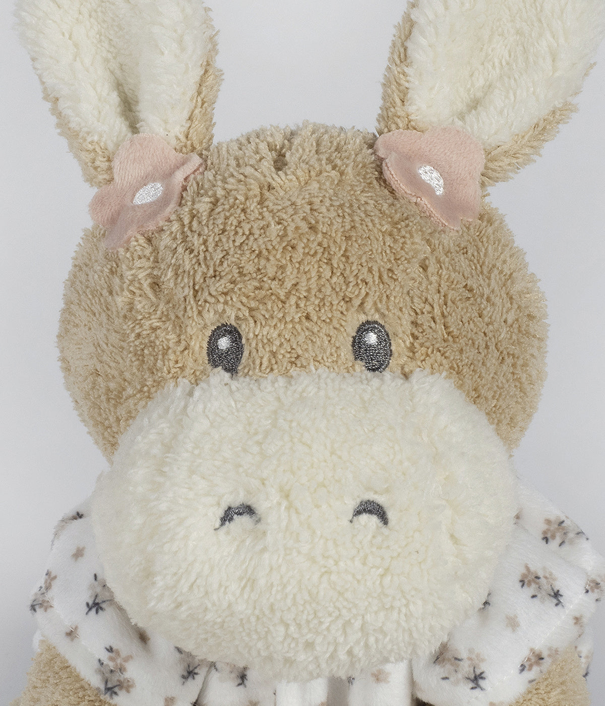 Peluche Walking Mum Botton Flowers para bebé menina e recém-nascida com 27cm em forma de burro de cor bege com orelhas e focinho em pérola e roupa com padrão floral.