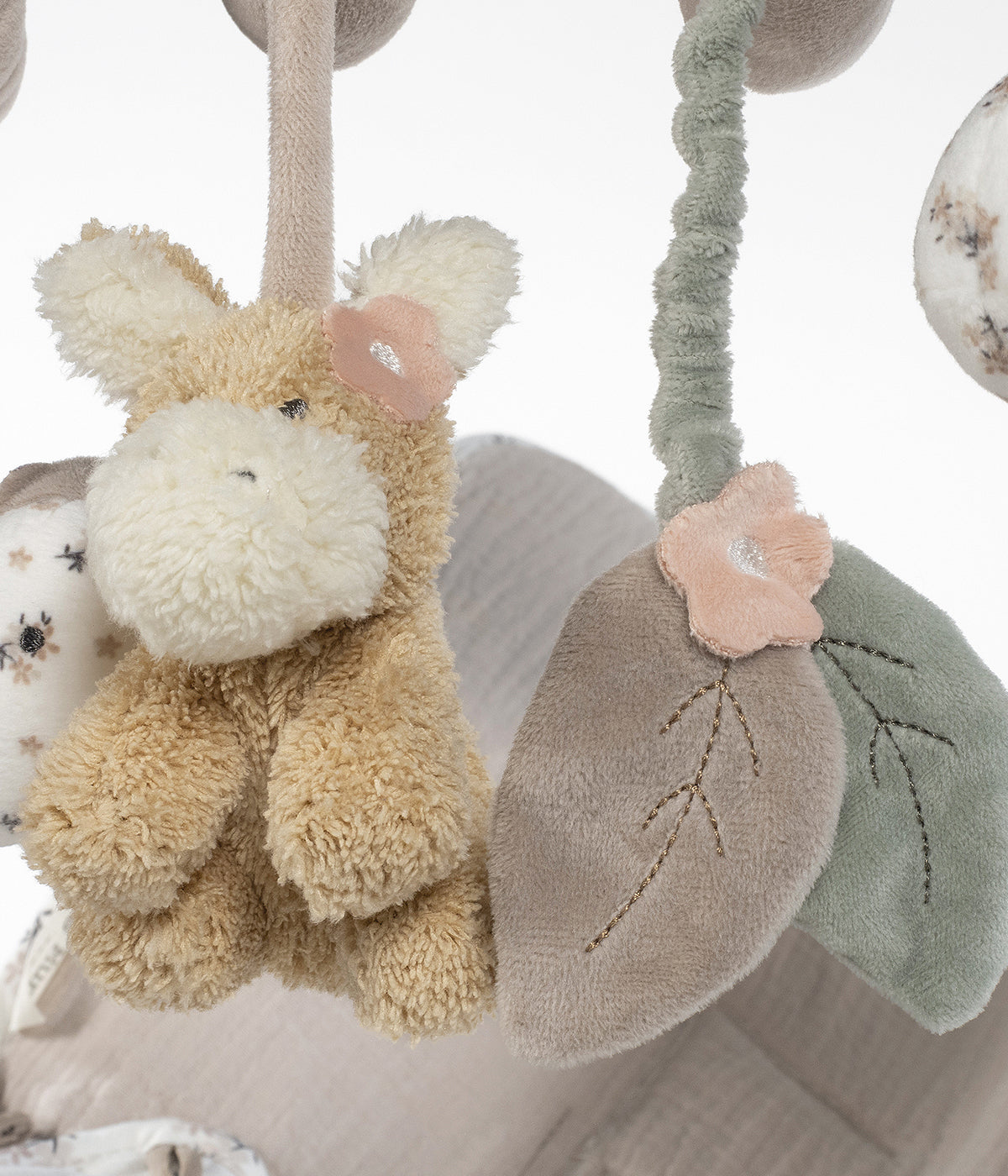 Espiral de atividades para bebé menina Botton Flowers da Walking Mum em tons de rosa e branco alia funcionalidade a estimulação sensorial. Prende-se facilmente ao carrinho, parque, ovo ou cadeira auto.